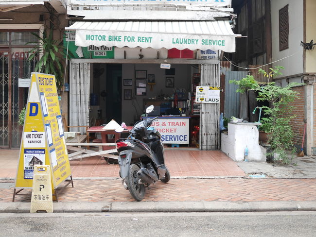 旅行代理店へはバイクで乗り付けた。<br /><br />ハンドルとシートの間にトランクをはめて載せる予定だった。が、トランクの幅が広く、それは無理。結局、トランクをバイクのシートの後ろにくくりつけ、朝のビエンチャンの街をトロトロ走って、到着した。<br /><br />前日にバスのチケットを購入した旅行代理店には8:10到着。指定された時間は8:30。ビエンチャンからバンビエンへのバスは、9:00発。<br /><br />到着後、トランクをバイクから下ろして、すぐ近くのゲストハウス兼レンタルバイク屋さん、Sport Guesthouse でバイク返却。<br /><br />あとは、バスが来るのを待つだけ。<br />まだ時間はたっぷりあった。<br /><br /><br /><br /><br /><br /><br /><br />