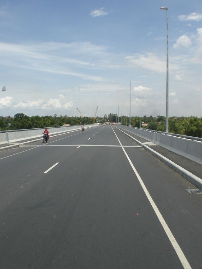 カンボジアには、現在、高速道路がありません。<br />高速道路建設に関する将来計画の検討に留まっています。<br /><br />写真は、メコン川に新設されたつばさ橋の様子です。<br /><br />一般住民生活の環境の中に建設された道路ですので、バイクが走っています。<br />国道１号線と合流した地域では、水牛や牛もともに利用します。<br /><br />メコン経済の中の南部経済回廊としては、安全な交通網が望まれています。<br /><br />将来的には、高速道路の整備が計画されることになるでしょう。