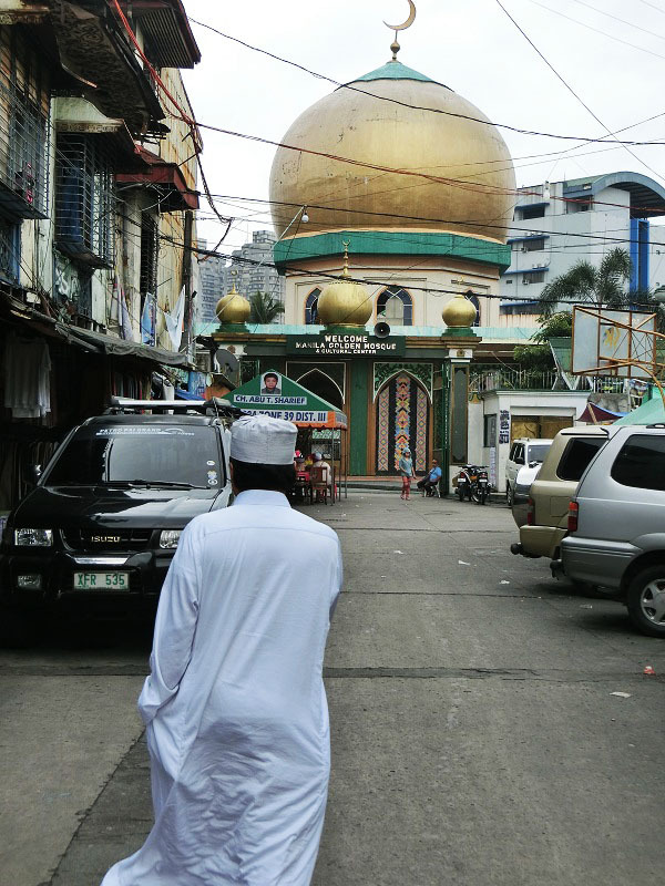一度訪れてみたいと考えていたマニラにある回教寺院・ Manila Golden Mosque へ行ってみた。地図を見ると、滞在先のチャイナ・タウンから近くにありそうだったので、歩いていくことにした。途中２回道を尋ねたが、何とか辿り着くことが出来た。　<br /><br />モスクがある近くに来ると、そこはもう今まで見てきたフィリピンの世界とは全く異なる異質な世界であった。道を行く人々はモスレムばかりで、女性は黒いチャドルで全身を覆い、男性は上下続きの白い服装をし、頭には回教帽を被っていた。<br /><br />この日は金曜日ではなかったので、参拝者は少なく、モスクには何ら問題なく入ることが出来た。最初に受け付けのようなところで名前と住所を書き、されに若干の寄付も求められた。