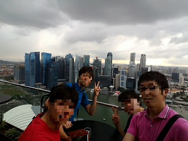 シンガポール　安い　１万円　旅行　マリーナベイサンズ<br /><br />皆さん，こんにちは。<br />私は，１万円で堪能出来る海外旅行を目指して旅をしています。<br />今回，訪れたのはシンガポールです。<br /><br />シンガポール　「マリーナベイサンズ　無料で最上階へ」編<br /><br />料金：０シンガポールドル<br />行き方：マリーナベイサンズの最上階に無料で行く方法は，ただひとつ。最上階にあるレストラン「Ｃ&amp;Eacute; ＬＡ ＶＩ(セラヴィー)」に行くことです。入り方は，まずマリーナベイサンズのタワー３の入り口近くにある専用受付に行きます。受付には，女性がひとり立っていますので，「セラヴィーに行きたい」と言えば，通してくれます。その際，「午後８時以降はドレスコードです。」と言われます。<br /><br />日本語：通じません。英語，中国語のみ，通じます。<br />店内：眼下にはマーライオンも観えますよ。テーブルはありますが，椅子がありません。手すりは，すりガラスになっています。ただし，屋根が無いので雨が降ったらどうするの？って感じのお店です。（一部，傘，屋根があります。）<br />テーブルがあって，ソファがある席もあるけど，お金持ちだけが座れるといった席でした。<br /><br />屋上にあがったら，写真をバチバチ撮りましょう。店員が近づいて来てメニューを持ってきます。アルコールは２０＄くらいから，ノンアルコールはオレンジジュースが８＄からです。写真が終わったら，そそくさとエレベーターで地上に降りましょう。他の欧米人も同じ様に注文せずに降りてました。<br /><br />