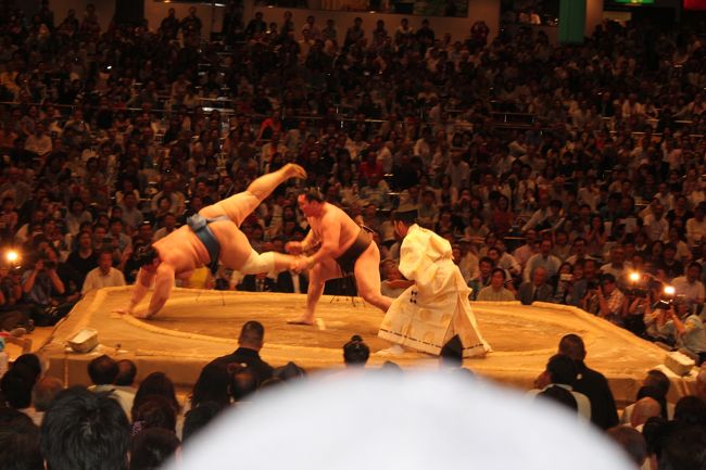 大相撲5月場所の観戦してきました。いつものように幕内の取り組みが始まる前に国技館に着くように行きました。チケットはいつもの様にお茶屋さんから送られて来るチケットで家族大人4人と幼児1名で行きました。席はいつもように向こう正面のマス席のA席です。入口から入りから入場してお茶屋の場所に行きます、バギーなどの荷物を預けお茶屋の人に案内されてます席に到着です、まだ周りのマス席で来てない所も有りますが今日もチケット売り切れです。席につくとすぐに弁当や飲み物やツマミなどをお茶屋さんが持ってきてくれます、ここでの楽しみは国技館名物の焼き鳥です、両国の国技館の地下に焼き鳥工場があり毎日作られています、これが冷めても美味しい味付けが人気です、この焼き鳥や幕の内弁当を食べながらの観戦はこのマス席ならでのは楽しみです。ところで本場所の時間割りは朝の8時開場だそうです、十両の取り組みは2時40分頃、幕内の土俵入りは3時45分頃、横綱の土俵入りは3時50分頃で幕内力士の取り組みが始まるのが4時15分頃からです、このころから小結／関脇／大関が登場します、6時前頃に結びの一番がありますその後は弓取り式で終了です。