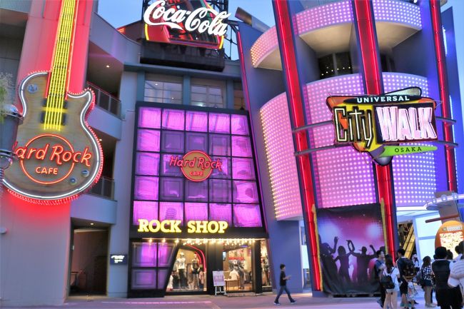 2016年6月25日、USJの前のハードロックカフェ ユニバーサルシティウォーク店が全面改装してリニューアルオープン。<br />※所在地・電話番号など変更なし。<br /><br />(2016年6月20日よりソフトオープン)<br /><br />USJからシティウォークに向かうと嫌でも目に入って来る巨大レスポールギターの看板は以前と同じです。<br />3Fロックショップのエントランスのキャディラックが無くなったのは個人的に残念です。<br />昼間はあまり目立たないが、新しくなった外観はイルミネーションが綺麗です。<br />4Fレストランエントランスもモダンな感じに変貌。こちらもイルミネーション多用してます。外から店内の様子が見難くなってます。<br />ロックショップもレストランも自動ドアにバージョンアップしてました。<br />以前のアイリッシュパブ風の感じもあったレストラン店内は一転。モダンなお洒落な内装に変貌してました。<br />メインにあったステンドグラスのエルビスも撤去されてロゴマークが設置されてました。ここはライブ開催時にはステージになります。<br />ドーム状の天井のギターを持った天使や大阪城のフレスコ画は塗りつぶされてました…<br />BARの位置も変わってテーブルが光ってた!しかも色が変わって…お洒落なんだろうが慣れてないので落ち着かない。<br />BARの椅子はなんかちゃっちくなったかな??<br />BARカウンターにコンセントが設置されて便利です! 以前のBARは喫煙可能だったが禁煙になってます。<br /><br />以前のBARがあった付近は個室ぽくなっててVIPルームなんかな??<br /><br />テーブル席のテーブルも椅子も一新されてました。場所によってはタイトな感じかな?<br /><br />シックな感じからモダンでLEDを多用した店内は今のハードロックカフェの主流なんだろな?<br /><br />ハードロックカフェの楽しみと言えばアーチストの愛用してた衣装や楽器がディスプレイされてることです。<br />リニーアルに伴いメモラリビアも一新!以前より飾ってる数は減りました。<br />そのメモラリビアの中に日本人アーチストの物が…違和感感じたのは事実だが…話題になるのでアリかな??<br />アルフィーの高見沢さんのフィリックスギター、D'esparisRayの衣装、モーニング娘のラブマシーンの時の衣装…<br />目玉商品?フリートウッド・マックのStevie Nicksの着物、Lady GaGaの衣装、Katy Perryの衣装、Black SabbathのTonnyの衣装など…<br /><br />客席数の少し増えた感じです。<br />Free wifiが設置されました!性別と誕生日の入力が必要です。親会社のWDIのサイトに移動して30分間無料で使えます。<br /><br />新しく生まれ変わったハードロックカフェ ユニバーサルシティウォーク店。USJに行った時にでも行かれてみては?<br />特に改装前に行った事がある方は激変した店内をご自身の目で確認してみれば??<br /><br />2017年10月より17時まで分煙ですが、17時以降全席禁煙になりました。<br /><br /><br /><br />改装前のレポは私の旅行記にあります…<br /><br />