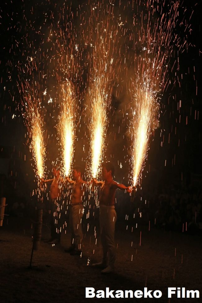 週明け前の日曜日。久々に関西本線に乗り三郷で降りる。龍田大社の風鎮大祭に行く。花火は９時から。汗だくになり家に帰ったのは夜１１時半であった。<br /> 　この風鎮（ふうちん）大祭は風しずめのまつりとされ、風水害、凶作、疫病が流行しこれらを鎮める為に風の神を龍田に祀りお祭りが行われたのが最初です。歴史は古く675年には国の祭りとして行われていたと日本書紀に記されています。砂かけ祭りの行われる広瀬神社の水神が水による生産の神であるのに対し、龍田大社の風神は悪風を防ぐとともに、荒雨を防ぎ、国家を鎮める神として祭られ対になっています。<br /> 　もともと日本は稲作文化が中心で、古代の人々は台風や水害の被害に遭えばたちまち生きることができないのです。だからこそ風水害を避け、豊作になってくれることを祈っていたのでしょう。<br /> 夜9時からはいよいよクライマックスの奉納花火です。あらかじめ、花火で燃えないように周辺を散水車で濡らしています。手筒花火をもった官司さんが筆頭になり次々と花火を点火します。<br /> 　見学は危ないので少し離れた場所からになります。この花火は一般でも参加でき、この時に募集しますが、男は上半身裸になる必要があります。服着ると焦げてたり燃え移ったりして危ないそうです。この火の粉はほとんど熱くないようですが、汗かいていてそこにあたると熱いそうです。女性は白装束を借りていました。<br /><br /><br />龍田大社（たつたたいしゃ）は、奈良県生駒郡三郷町立野南にある神社。式内社（名神大社）、二十二社（中七社）の一社。旧社格は官幣大社で、現在は神社本庁の別表神社。<br /><br />旧称は「龍田神社」。風の神（風神）として古くから信仰を集める。<br /><br />祭神<br /><br />祭神は次の2柱。<br /><br />天御柱命（あめのみはしらのみこと）<br />国御柱命（くにのみはしらのみこと）<br /><br />龍田の風神と総称され、広瀬の水神と並び称された。同社の祝詞などでは、天御柱命は級長津彦命（男神）、国御柱命は級長戸辺命（女神）のこととされている。<br /><br />歴史<br /><br />『延喜式』祝詞の「龍田風神祭祝詞」によれば、崇神天皇の時代、数年に渡って凶作が続き疫病が流行したため、天皇自ら天神地祇を祀って祈願したところ、夢で天御柱命・国御柱命の二柱の神を龍田山に祀れというお告げがあり、これによって創建されたという。<br /><br />国史では、天武天皇4年（675年）4月10日に勅使を遣わして風神を龍田立野に祀り、大忌神を広瀬河曲に祀ったと『日本書紀』の記述が初見である。<br /><br />延長5年（927年）成立の『延喜式』神名帳では大和国平群郡に「竜田坐天御柱国御柱神社二座 並名神大 月次新嘗」として、二座が名神大社に列するとともに朝廷の月次祭・新嘗祭で幣帛に預かった旨が記載されている。<br /><br />明治維新後、明治4年（1871年）に近代社格制度において「龍田神社」として官幣大社に列した。<br /><br />紅葉の名所としても有名である。摂社・龍田比古龍田比売神社の祭神である龍田姫は秋の女神とされ、古来より多くの歌に詠まれてきた。<br /><br />風鎮大祭<br /><br />例大祭と同じ意味合いのお祭りで、年間祭事中、最も重儀です。<br /> 行事は祭日１週間前から前日までの、１日２度の御饌祭（みけさい）*に始まり、結願日（けちがんび）である７日目に風鎮大祭が行われます。祭典後には、剱舞や民踊などの神賑奉納行事が行われ、火のごちそうである「風神花火」をお供えし風鎮大祭の締めくくりとなります。<br /> *御饌祭：朝食・夕食をお供えすること<br /><br />当日予定<br /><br />風鎮大祭詳細 神賑行事予定<br /><br />居合剱詩舞道奉納（午後2時〜3時）：<br /> 柳生新陰流の「居合」の静から動への一瞬の気迫と、日本水華流の「剱舞」華麗なる動きには目を奪われます。<br /><br />家内安全龍田神楽奉奏（午後1時〜4時）：<br /> 家内安全・商売繁盛をご祈願するお神楽をお受けいただけます。<br /><br />安岐風神太鼓奉納（午後5時〜6時）：<br /> 岐阜県中津川市鎮座風神神社に伝わる風神太鼓の奉納。<br /><br />風神太鼓奉納（午後6時半〜7時）：<br /> 当社に伝わる風神太鼓の奉納。<br /><br />河内音頭・民踊奉納（午後7時半〜9時）：<br /> 拝殿前広場に立てられた提灯を中心にして、三音会の音頭に合わせた賑やかな民踊が繰り広げられます。参加は自由になりますので皆様も進んで踊りの輪に加わって下さい。<br /><br />風神花火奉納（午後9時〜10時）：<br /> 神様に火のごちそうである「風神花火」を奉納します。花火の力強くも美しいさまは見るものを引き付けます。ご希望の方は風神花火を持つことも可能です。<br />さて妄想へ　著者注）<br />本紀行は、写真撮影記に私の妄想が入り、過去の人物などが出る事があります。入江：入江泰吉　土門：土門拳　佐藤：佐藤義清　楠木：楠木正成<br /> 三郷の駅を降りるといかつい男が待っていた。<br />楠木さんである。<br />私「今日はおひとりですか」<br />楠木「今日は、わいがお相手するやんけ」<br />