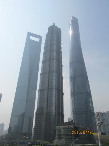上海の陸家嘴には３棟（上海中心大厦、上海環球金融、高さ492m、104階、展望台の高さ（地上474m）。金茂大厦（高さ420.5m、88階））の超高層ビルが完成しました。1993年に作られた陸家嘴金融貿易区の完成予想図では、飛びぬけた高さの三本の超高層ビルが隣同士に描かれていました。23年経って予想図が完成しました。ゲンスラー社の案はガラス・カーテンウォールで外側を覆われたビルが螺旋状にねじれながら高くなってゆくという案でした。まるで龍が天に向かって登って行く中国が一番好きな構図です。陸家嘴には他にも多くの高層ビルが建ち並ぶ摩天楼、３棟の超高層ビルを写真に収める為、周辺の東泰路・銀城中路・花園石橋路・陸家嘴環路を炎天下の中歩いて見ました。３棟が重ならない様に写真に撮れる場所はなかなかありません。<br />