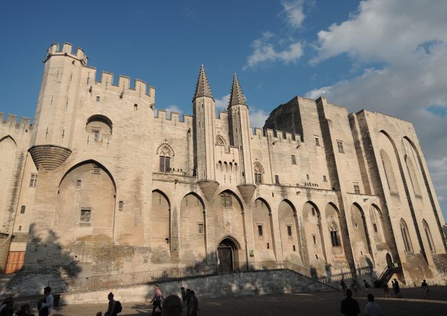 Avignon （アビニヨン）は南仏・Vaucluse（ヴォクリューズ）県の県庁所在地で人口は約9万人、こじんまりとした地方都市です<br /><br />しかし中世の昔ここにカトリックの総本山である教皇庁が置かれ、いわばキリスト教の首都であったことを知る人は少ないと思います（実を言うと私もその一人です）<br />・・・・・・・・・・・・・・・・・・・・・・・・・・・・・・・・・・・<br />13世紀後半教皇の権威が失墜、反面各国の国王の力は増大し教皇とことごとく対立するようになった<br /><br />1294年に教皇となったイタリア人のボニファティウス8世は王権は教会に隷属すると考え各国の内政に干渉、また権力乱用によりローマは退廃しつつあった<br /><br />これに対しフランス国王フィリップ4世は教会に納める税金を凍結し抗議したが教皇は信者にローマ巡礼を強要し巨額の浄財を集めた<br /><br />両者の対立は更に激化しついには国王側は教皇をフランスに拉致するまでに至った<br /><br />そのような中フィリップ4世に推されて教皇に選ばれたのがクレメンス5世で、彼は国王の意をくんで1309年教皇庁をアビニヨンに移した<br /><br />アビニヨン教皇庁時代はその後68年間続くことになる<br /><br />この出来事をイタリア人は旧約聖書にある「バビロン捕囚」になぞらえて「アビニヨン捕囚」と呼んで非難している<br />・・・・・・・・・・・・・・・・・・・・・・・・・・・・・・・・・・・・・・・・・・<br />今でも当時の教皇庁宮殿や大司教館などの建築物が多数残っており「アビニオン歴史地区」として19995年世界遺産に登録されています