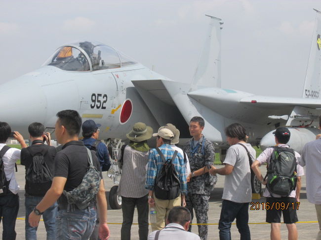 横田米軍基地は３０００ｍを超える滑走路を持っている。即ち、縦横の長さが３キロを超える日本有数の長大滑走路で、先月横須賀で日本最大のヘリ空母「いずも」に乗船し、その長さ３００ｍに近い飛行甲板を見て、小学校の運動会場よりも長い滑走路に驚いたが、この横田基地はそれよりも１０倍以上も長い。もう今から半世紀以上の前、この滑走路拡幅工事に反対する学生運動と、機動隊とが滑走路先端付近の砂川町で衝突し、何人かの死傷者も出て、砂川事件、砂川闘争として今に記憶されている。<br /><br />今日案内してくれた基地傍に住んでいる森さんの話では、自宅が基地の横側にあって、航空機の騒音は殆ど気にならない、とのことを話していたが、この滑走路の前後、進入路と離陸路の下に住んでいる住民は、相当な音に悩まされているとのことだった。それも当然だろう。機体だけで１００トンもありそうな超大型輸送機Ｃ−１３０が貨物を満載して飛び立ったり、最新鋭の戦闘機がフルパワーで飛び立つ時の騒音など、経験しないと想像もできないだろう。<br /><br />この広大な滑走路に並んで空自の最新鋭戦闘機が展示されている。尉官クラスの隊員、整備兵なのかパイロットなのかは不明だが、飛行機オタクの観客の質問に丁寧に答えている。多分同じような質問を多くの観客から繰り返し聞かれたのであろう、半ばうんざりした顔付であるが、納税者には丁寧だ。ネームプレートを見ると百里基地からやってきているようだ。百里は鹿島灘の海に面していて、太平洋上の訓練空域も十分に確保でき、この少尉か中尉か、普段は青空の元で思いっきりスロットルを開いているだろうが、今日の航空祭、素人マニア相手に、どうもご苦労さん。<br /><br />三菱各務原からスタートした日本の航空産業、一時は名機ゼロ戦なども製造し、世界をリードする航空大国になったが、戦争に敗れ、製造は禁止され、戦後漸くターボプロップのＹＳ−１１を生んだが、その製造も間も無くで中止され、現在産業界の渇望の元、三菱ＭＲＪの初飛行にこぎつけたが、幾つかの手違いも生じ、その前途は多難だ。が、民需では戦後７０年経って、漸く本格生産に乗り出しつつあるが、軍需に於いては、米英仏には全く足元にも及ばない。この滑走路にズラっと並んでいる最新鋭ジェット戦闘機はすべてが米国製だ。1機１００億を超える。１００億あればどれ程の民政に生かされるか。今や防衛予算は厚労省に次ぐ巨大なものになっている。がしかし、半分が借金漬けの国家予算、年々増大し既に８０兆円を超えているので、国防予算はそれでもまだ１０％ルールの枠内に収まっている。目の前の最新鋭の戦闘機を眺めつつ、税金の在り方、今後の日本の国防の在り方、等等考えた。