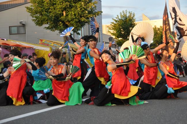 近年、栗山秋祭りでは、地元のＹＯＳＡＫＯＩソーランチーム「くりやまＯＨ夢乱咲」をはじめとして、町外のＹＯＳＡＫＯＩソーランチームを招聘して演舞披露しているが、今年は何と、札幌のＹＯＳＡＫＯＩソーランでファイナルの常連であり大賞や準大賞を何度も受賞している、<br />新琴似天舞龍神（大賞６回、準大賞４回、今年の本祭で準大賞）、<br />平岸天神（大賞９回、準大賞８回、今年のファイナル優秀賞）、<br />夢想漣えさし（大賞３回、準大賞３回、今年の本祭ファイナル優秀賞）<br />も来町して１６チームの参加という、かつてない規模と豪華さで開催された。これは今年の曜日配列で２４日が土曜日だったため可能になったということ。<br /><br />会場は栗山駅前通りの道路であり、札幌のＹＯＳＡＫＯＩソーラン会場のようにパレード方式で披露される。なお私は公式カメラマンとして緑のジャンバーと赤い腕章をして自由に撮影できたが、時間の経過とともに沿道は多くの人で溢れ、公式カメラマンであっても自由に身動きがとれないこともあった。<br />なお画像そのものは相当数撮影したので、複数に分けて掲載したい。<br /><br />