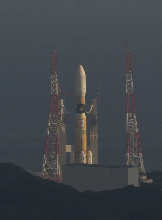種子島でロケット打上見物。今回は2回目となりますが、はじめて行く人のために、やはり予約取りから。ながーい旅行記になるので面倒な人はスルーしてね。<br /><br />前回ははやぷさⅡのHⅡAロケットでしたが、今回はこうのとり6号のHⅡBロケット。あの固体燃料ロケットブースターが4つあって胴体が少し太くてくびれてるやつ。<br /><br />1.まずは打上予定日<br /> 打上予定日はほぼ2ヶ月前に公表されますが、公表されてからでは宿とかレンタカーの予約がなかなかとりにくい。<br />そこで、公表の前に打上日を予想することは出来ないだろうか? と考えていろいろネットで情報を探してみました。ありました。<br />そのものズバリの情報はありませんが、いろいろな情報を総合してある程度特定することができました。<br />どんな方法か? 残念ですが公表できません。ノウハウを知っている人(私を含めて)のアドバンテージを侵すことになって非難ごうごうになるだろうから。<br /><br />なお、公表前の打上日の事前特定の精度としてはまあかなり高い。<br />今回のこうのとり6号の当初打上予定日は2016.10.1(午前2時頃)。打上日の公表(約2ヶ月前)より一ヶ月近く前に、9月30日~10月1日と読んでいました。<br />次は、11月1日打上予定だったひまわり9号。これも予想は11月1日とドンピシャ。<br />そして、今回のこうのとり6号がメカトラブルで打上延期になったあとの再設定日も、実際は12/9だったけど公表の2週間くらい前から12/6~7と読んでいました。多少ずれましたが、予約を長めに取っていたので12/9は予約の中に入っていました。<br />いずれにしてもかなりの精度で予想することが可能で。それが出来ると宿なんかの予約がかなり取りやすくなります。<br /><br />2.予約取り<br /> ロケット見物の予約でまず最初に埋まってゆくのがレンタカー、宿、鹿児島→種子島の飛行機。<br />今回は打上日公表の前にほぼ特定できていたので楽でした。<br /><br />まずは宿。種子島にいろいろ民宿やらホテルやらあるし値段もまちまち。<br />今回狙ったのはビジネスホテルの素泊まり。<br />ただし、天候による打上延期にも対応できるようある程度延長したスケジュールで予約を取ることになる。そして天候の状況を見ながら延長部分をキャンセルしてゆくことになる。今回は12/5~12/10くらいのスケジュールで最初予約して、打上日公表後に12/9~の予約に変更。天気予報を見て「晴れ」が続いていたので打ち上げ延期ないと踏んで、打上日3日前くらいに12/10(打上日)以降の予約をキャンセル。<br />レンタカーもほぼ同じようにして予約を調整。これで宿と現地の足となるレンタカーを確定。<br /><br />次が往路。住所地から鹿児島までの飛行機はいつでも予約できる。ただし、出発時間帯によってチケット代が3倍以上高くなるので、一番安い夕方発の便を予約。打上日の前日(12/8)の夕方の便で鹿児島着にして、その日は鹿児島の安ーいビジネスホテル(素泊まり3000円前後で数件あり)で一泊。<br />翌朝高速船で種子島へ という予約内容。<br />これでも12/9昼間の飛行機で鹿児島行くよりかなり安い。<br /><br /><br />そして帰りの予約。<br />打上日(12/9)の翌日(12/10)すぐに帰るとして、種子島→鹿児島の飛行機の予約。2ヶ月前の応当日の9:30から予約可能ということで、10/10 9:20くらいからパソコン前で準備していたけど、9:30に画面を更新して予約画面を表示させたらすでに12/10の朝一の便は満席。<br />ちなみに、行きの12/9の鹿児島→種子島の飛行機も、12/9の9:30に画面が更新になるとすでに全便満席でした。<br />どうなっとるねん。関係者が先にすべて押さえたか。<br />ま、12/10は種子島観光して帰る手もあるので、12/10午後の便を予約。<br />予約開始日ならこんな予約取りもできるということらしい。<br /><br />3.いよいよ出発 鹿児島へ<br /> 12/8 夕方発の飛行機で鹿児島空港へ。1時間ちょっとで鹿児島空港着。<br />予定では30分ほどの待ち合わせで鹿児島市内行きのバスがあるはず。<br /><br />預けた荷物を受け取って空港をでるとすぐそこがバス乗り場。<br />鹿児島市内(天文館通り)までの運賃1420円だったかな、自販機で購入。<br />すぐそこのバス停に止まっていたバスで天文館行きを確認して乗り込みました。スーツケースはバスの横腹の荷物入れで預かってくれます。<br />席はまだ少し空きがあって着席。すぐに満席になって、補助椅子もいくつか使って、いよいよ出発。<br /><br />始めは高速道路(有料道路?)を調子よく走りますが、しばらくすると街中一般道へ。もう夜8時過ぎているので街中でも空いています。<br />途中のバスストップを2、3停車していよいよ鹿児島中心街天文館バス停。<br />降車してホテルを探します。すぐに分かりました。歩いて1分くらい。<br /><br />素泊まり一泊3380円のビジネスホテル。格安。<br />チェックイン後、フロントで食事できるところを教えてもらって夕食。いまどき珍しい定食屋さん。いろいろ食べてしまいました。<br />そして朝食も同じ店。おいしくいただけました。<br /><br />4.種子島へ<br />12/9、ホテルチェックアウトして、高速船のターミナルまでの時間を聞くと、歩いて20~25分とのこと。実際に歩いてみると20分くらい。<br />天文館あたりのホテルからだとこんな時間でいけます。ご参考まで。<br /><br />さて、高速船ターミナル。出航が10:00予定。9:00頃着いて予約票を見せて指定席券に換えます。時間があったので、港から見える桜島を写真に撮ろうとしたら、霞んでいてぼやーっとした写真にしかならず。残念。<br />時間になって乗り込みます。以前もそうでしたけどこの日も風が無くて波はとても静か。ほとんど揺れず新幹線並。<br />途中でアナウンスが入って、右を見ると開聞岳。初めて見ました。<br />約1.5時間で種子島着。<br />港から歩いて宿へ向かいます。徒歩10分くらい。ビジネスホテルいのもと。まだ12時頃でチェックインは出来ませんが、荷物を預かってもらう。<br />そのまま昼食へ。系列の味処井元で軽く腹ごしらえ。<br />その後また港へほ戻ってオリックスレンタカーで予約していたレンタカーを受け取り。<br />明日の13:30ころ返却予定だったので、レンタカー借り出しの時間も今日の13:30頃にして、レンタ期間をちょうど1日にしてレンタ料金を節約します。<br /><br />5.種子島観光<br />打上は今日の午夜10時20分過ぎなので、昼間は観光します。<br />まずは鉄砲館。種子島の歴史や鉄砲の展示がたくさんあってそこそこ楽しめます。以前来たときは館内撮影禁止でしたが、今回来てみるとごく一部を除いて撮影可だったので展示物の写真を撮らせてもらいました。<br /><br />続いて月窓亭。種子島の豪族(武士)の館。案内係のおじさん、おばさん達がいて説明したりしてくれます。ビデオで説明を見たり狭い屋敷内を見物したり。素朴な感じで楽しめます。<br /><br />つぎは打上見学予定地の長谷公園の下見。港から車で約45分。一本道で分かりやすい。信号もほとんど無し。ただし、前回もそうだったが、車のナビの目的地設定がやりにくい。施設名や電話番号で検索できない。ナビに地点登録もしてない。しかたないので、地図と照らし合わせて場所を特定してピンポイントの場所を目的地設定。<br />種子島の有名どころなんだから地点登録くらいしておいてまれればいいのに、といつも思います。次に出でくる門倉岬や千座の岩屋も同じこと。<br /><br />長谷公園に着いて5Km先の発射場を見てみると、ロケットはすでに発射台に移動済。夕日が横腹に当たったHⅡBロケットの姿が撮影できました。<br />念願のHⅡB。ブースターが4本で、2本のHⅡAよりもやっぱり迫力があります。<br /><br />続いて種子島観光定番の門倉岬。前回来たときは強風と曇り空で悲惨な風景でしたが、今回は風が少しあったけどほぼ良い天気でした。<br />青い空と青い海を崖の上から撮影して門倉岬観光はおしまい。<br /><br />次に向かうは千座の岩屋。前回来たときはやっぱり超強風と曇り空、満潮で面白くもなんとも無かったけれど、今回は晴れで干潮。岩屋の空洞の中も歩けて、やっと千座の岩屋らしい体験が出来ました。景色もそこそこ良かった。<br /><br />観光はこのくらいにして宿に帰って、食事をして、いよいよ打上見物に出発します。<br /><br />続きは 「種子島 HⅡBロケット打上見物 ②」へ。 <br /><br /><br /><br /><br /><br /><br /><br /><br /><br /><br /><br /><br />