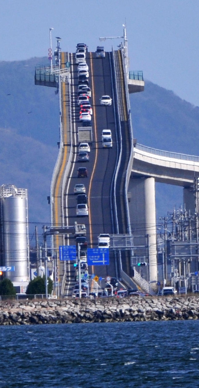 境港に到着した翌日は天気も良く、絶好の散策日和です。<br />まずは江島大橋に行ってみることにしました。<br />余子駅までは境線で行き、そこから３０分くらい歩く江島大橋に到着です。歩道もあるので歩いて渡れます。<br />結構、高いところを歩くので、ちょっと怖かったです。<br />江島大橋を渡り、江島そして大根島まで向かいます。歩くこと１時間弱かかり、ようやく目的地に到着です。<br />「ベタ踏み坂」こと江島大橋が壁にように見える場所です。<br />しかし、到着すると海風が強くなり、カメラを構えてもカメラが揺れ、三脚を使っても、やっぱりカメラが揺れます。<br />持って行った望遠レンズでも、橋は小さく、ちょっと残念でした。<br />境港の戻ってからは、町を少し歩いて、初日は終了です。<br />翌日は境港の町を歩いたり、水木しげる記念館に行ったりして、午前中を過ごします。<br />午後は鬼太郎列車で米子に出てみましたが、雨が降ってきたので、米子散策は諦め、境港に戻って、町をぶらぶらして過ごしました。