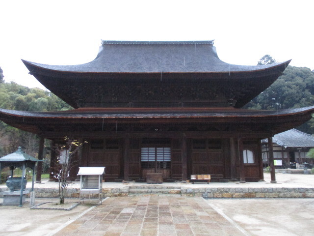 新日山安国寺不動院（ふどういん、広島県広島市東区牛田新町）は元の名は安国寺といい、戦国大名となった毛利家の外交僧として活躍、秀吉治世下では秀吉の交渉役としての功績により僧籍に属するも、伊予国和気郡を知行地とする２万３千石（後に加増され６万石）の大名に遇されます。<br /><br />関ケ原合戦では西軍が敗れ毛利元就の孫輝元（てるもと）を西軍の総大将にまつり上げる交渉を実現させたことにより首謀者の一人として京都六条河原にて斬首された安国寺恵瓊（あんこくじ・えけい、１５３９？～１６００））が住職を務めた寺院で、恵瓊が死亡した後は犯罪者扱いされたため安国寺の名を憚り『不動院』に改名したとされます。<br /><br />もともと恵瓊は八幡太郎義家を兄とする新羅三郎義光を遠祖とし、甲斐武田氏の流れを汲む鎌倉時代以来の安芸国守護を任じた武田氏一族に生まれ、父は安芸守護を務めた武田信重（たけだ・のぶしげ）と伝えられます。戦国時代では対立関係にあった大内氏の命を受けた毛利元就によって本拠の銀山城を攻められ当主信重は自害し武田氏が滅亡、信重嫡男竹若丸は家臣らに守られて脱出し太田川の対岸の安国寺に逃れて出家し命が救われます。<br /><br />後に竹若丸は京に上り東福寺の竺雲恵心（じくうんえしん）の弟子となり恵瓊（えけい）と名乗る事になりますが、毛利元就の長男である隆元（たかもと）と親交あった恵心は恵瓊の優秀さを見抜き彼を毛利家の外交交渉を担う外交僧に抜擢します。<br /><br /><br /><br />桜門に至る参道の途中に配されている掲示板には不動院内の見取図と共に歴史が次の通り記されています。<br /><br />「新日山安国寺　不動院の歴史<br /><br />新日山安国寺不動院は江戸時代の『新山雑記』では、当寺の開基は僧空窓であると伝えられていますが、創建の時代や由緒については判然としていません。<br /><br />ただ金堂内に安置されている本尊薬師如来が定朝様式であることから、当寺は平安時代には創建されていたと推察されています。当寺が安国寺不動院と呼ばれる由縁は足利尊氏、直義兄弟が日本六十余国に設立した安国寺の一寺であったことに由来します。以後、安芸安国寺として、又、安芸国守護武田氏の菩提寺として繁栄しました。<br /><br />しかし、戦国時代の大永年間（１５２１～２７）、武田氏と大内氏の戦いにより安国寺の伽藍は焼け落ちてしまいました。その後五十年は藁屋に本尊薬師如来を安置する有様であったと記録されています。<br /><br />当寺を復興したのが、戦国大名毛利氏の外交僧として、又、豊臣秀吉公直臣大名として戦国の世に名高い安国寺恵瓊です。恵瓊はこの間この間当寺の伽藍復興に努め、金堂、桜門、鐘楼、方丈、塔頭十二院などを復興整備し、寺運は隆盛を極めました。しかし、関ケ原の合戦で西軍に組した恵瓊は非業の死をとげ、毛利氏も防長二国に国替えとなりました。恵瓊なき後、寺領は没収となり、寺運は次第に衰えてゆきました。<br /><br />毛利氏が去った後、福島正則が芸備両国四十九万石の大名として入国し、正則公の祈祷僧である宥珍が入り、住持となりました。この時、宗派を禅宗から真言宗に改め、不動明王を本坊に移して本尊とし、本坊を不動院と称しました。後に当寺全体を不動院と称するようになりました。正則公の治世は二十年足らずで終わり、浅野氏が新しい国主として広島に入りました。以後、藩政時代を通じて浅野家歴代藩主の保護を受け、概ね安定した時期が続きました。やがて明治に入り、当寺は時代の権力者の手から離れ、庶民の信仰の場となりました。<br /><br />原子爆弾投下に際しても地理的条件が幸いして罹災を免れ、一瞬にして多くの文化財を失った広島にとって、昔の栄華を今も留める極めて貴重な存在となっています。」