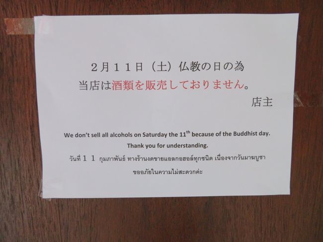 バンコク旅行２日目の２月１１日（土）<br /><br />その予兆は、宿泊したホテル近くのロビンソンの地下にあるトップスマーケットでビールを買おうとしたときにあったのです<br /><br />午前中にマッサージに行ってお昼近くになり、「あー、喉かわいた～。冷たいビールでも飲もっ」と、と何の疑問もなく、トップスマーケットに入った私<br /><br />ビール、ビール、と売り場に向かっていく途中にある「WINE CELLAR」（ワインやウイスキーなどはここで売られています）がカーテンで閉じられているのに気が付き、？何で閉めてるのかなぁ、と思ったのです（この時点ではまだ今日これから起こる悲劇に気が付いていません）<br /><br />んー、あれビール売り場どこだっけ、と久しぶりのトップスの中でビールを見つけられない私<br />「あー、あったあった」と売り場の途中にある小さな冷蔵庫の中にいかにも大事そうに並べられているシンハ、チャン、ハイネケンなどの缶ビールたち<br />「あれ、こんなもんだっけビール。いつもは棚にズラッと並んでるのに」（そのとき、冷蔵庫の扉に紙が貼られ何か書いてあったのですが、この時点に至ってもまだ今日これから起こる悲劇に気が付いていません）<br /><br />冷蔵庫を開けて、「あ、これまだ入れたばっかりだね。生ぬるいや。お、こっちは冷え冷え」とシンハを取り出し、レジに向かおうとしました<br />すると、私を見たお店の女性が、ニコニコしながら後ろを指さしています。ん？と振り返りますと、いましがたビールを取り出した冷蔵庫の前で、やはりニコニコしながら手招きする男性がいます。<br />なーに、もっと冷えてるのがあるって教えてくれるのかなぁ、などと嬉しくなってニコニコしながら男性の前に行くと、私が持っていたビールをとって冷蔵庫の中にしまいます<br /><br />親切だなぁ、もっと冷えたビールのところに案内してくれるんだ、そうだよね、いつもと売り場が違うもんね、と思っていると、「これ読んで」と冷蔵庫の扉に貼られた紙を指さします<br />ふんふん。と読み始めた自分の顔がガッカリしていくのが分かりました<br />「本日はブッダの日なのでお酒売れません」という意味のことが書いてあります<br />「えー、そうなの。そんな日は知らなかったよ」と思いましたが、ただ、この時点ではまだ事態の深刻さには気が付いていなかったのです。なぜなら、バンコクでは日と店によってはある時間帯にお酒を売らないことがあるためで、何度かその場に遭遇したことがあったからです<br />「ま、いっか。夕方から思う存分飲んでやれ」と店を後にし、買い物に出かけたのです<br /><br />買い物を終えてＢＴＳに乗りホテルに戻る途中、後ろにいた日本人の３人家族（パパさん、ママさん、娘さん）が今夜の夕食をどこで食べようかと相談をしていて、どうやら今夜は日本の料理を食べにいくようです<br />するとママさんが、「あ、パパ。今日は禁酒日だから飲めないね～」と言い、パパさんが、「そっか！禁酒日かっ。でもあそこは日系の居酒屋だし大丈夫だろ」と応じています<br />このときようやく私は、さきほどトップスで見た告知文書が重大な意味を持っているのではないかと気付き、「もしかして今日マジでお酒飲めない？」という不安が頭をもたげました。「いや、でも全部のお店じゃないっしょ。ホテルだって商売だし、プールサイドバーでは飲めるっしょ」と根拠のない希望を持ってＢＴＳを降り、ホテルに戻ったのです<br /><br />ホテルの前には小さなバーがあり、昨夜はそこで飲んだのですが、今日はシャッターが閉められています。ホテルに隣接するアイリッシュ・パブにはインサイドの席とアウトサイドの席があり、アウトサイドのお客が飲んでるものをチラッと見ると、ビールを飲んでる人は一人もおらず、その代わり、ピッチャーに並々と入っている「コーラ」をがぶ飲みしています<br /><br />私の心を覆う暗雲<br /><br />ホテルに入り、１階にあるオールデイダイニングの前を通りかかったとき、立てかけられたメニューの隣に並べられた「白い紙」に気が付きました<br /><br />やな予感<br /><br />読み始めた私はついに希望が絶たれたことを認識したのです<br />「親愛なるお客様　本日２月１１日はブッダの日であり、法律によりアルコールの販売が禁止されています。当ホテルのすべてのレストランではアルコールを提供することができません。お食事とノンアルコールの飲料はお楽しみいただけます。ホテルマネージャー」<br />マジっすか、マジで？本当に全土で禁酒！<br /><br />それでも諦めきれない私は、「プールサイドバーはバーであってレストランではないから例外かも」と無理やりこじつけ、最上階に向かいます<br />エレベーターを降りて、昨夜もきた愛しいプールサイドバーを見た私は、ついに最後の希望が叩き潰されたことを知ります<br />昨日は、大勢のお客で賑わっていたバーには人っ子ひとりおらず、スタッフは手持ち無沙汰そうにしています<br />一応聞いてみようかと思ったのですが、バックバーに一本の酒ビンも置いていないことに気が付いた私が呟いた一言は、「そんな殺生な」でした<br />