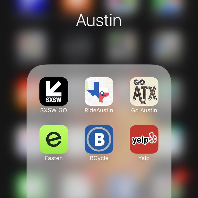 オースティンで開催されるSXSWに最適化させて、iPhoneのアプリをフォルダにまとめます。<br /><br />左上の「SXSW GO」というアプリは、SXSW参加者必携のアプリです。デイリーのスケジュールを確認し、自分が参加したいものに「★」をつけ、iCalに同期してリマインダーをセットすると大変便利。さらに、映画の上映については、各シアターの混雑状況がリアルタイムで一覧できるし、シャトルバスの運行状況もリアルタイムで把握できます。SXSWは会場がけっこう分散しているので、このアプリを使いこなさないと、恐ろしほどの非効率に陥ります。