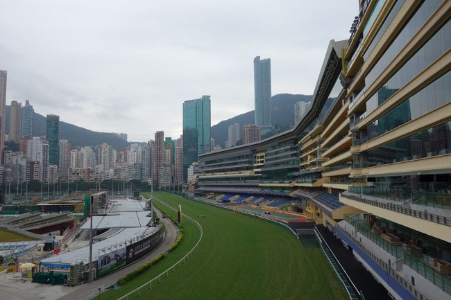 【これは別の日に撮影した昼間の“Happy Valley 競馬場”。ホームストレッチ側は延々室内観覧席が続いています。】<br /><br />香港に２つある競馬場のひとつ、“Happy Valley 競馬場”は夏場を除く、毎週水曜日にナイターが開催されているようです。現在駐在中の会社は、香港ジョッキークラブの会員になっているようで、とある水曜日に職場のイベントが開催されるとのことで参加。<br /><br />競馬はもともと英国文化のせいなのか、入場の際のドレスコードはきびしめ。紳士・淑女然としていないと会員席には入場させてくれないようです。<br /><br />会員席は、完全個室。その個室内で馬券も購入できるすばらしい雰囲気！馬券の購入は、最低ＨＫ＄１０から。というわけで、倍率ボードを睨みつつ、開始から毎レース最低倍率の馬券を購入、見事５連勝を達成しました。