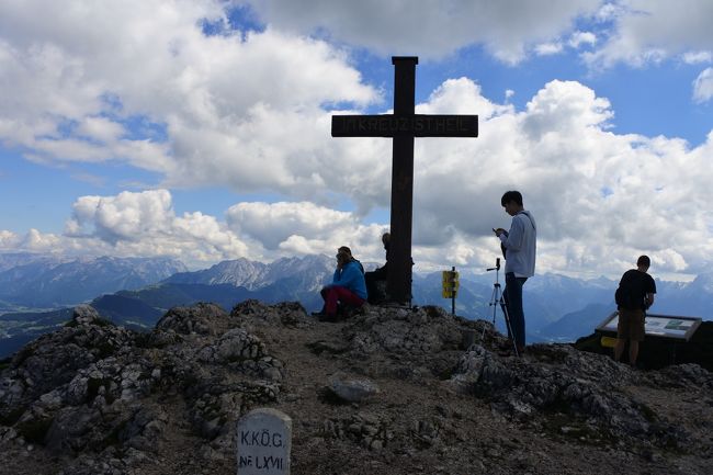 昨年のドレスデンひとり旅に味をしめて、同じドイツ語圏なら何とかなるかなあと、オーストリアを鉄道で横断しました。旅行中に５５歳となり、年相応、自分流を模索する旅となりました。<br />【５日目】午前：ザルツブルク市内を見下ろす尾根をハイキング 午後：バスとロープウェイで郊外ウンタースベルクへ<br />ザルツブルクカードを購入しての市内散策。まずは現代美術館のエレベータで高台へ。素敵な散策路を見つけ市内を見下ろしながらホーエンザルツブルク城塞めざして歩きました。当初ケーブルカーに乗って城塞を見学するつもりでしたが、夏休みの日曜だからか遠くから城塞の外に溢れる大行列を見て諦めました。旧市街へ降りてしばし散策。観光客の多さに疲れてしまい、昼食もとらず、いったんホテルへ。ザルツブルクカードには郊外にあるウンタースベルクのロープウェイと市内からのバスに１往復だけ乗れるとあったので午後から行ってみることにしました。ヘルブルン宮殿や動物園を通るバスに３０分ほど乗って麓まで。ロープウェイで一気に標高２千メートル付近まで上がりました。雲上の絶景を見ながら１時間ほどハイキングを楽しみました。<br />