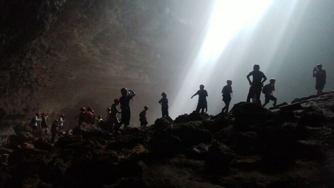 2023.02.12放送の世界の果てまで イッテQ ガンバレルーヤのワールドツアー in インドネシアに出てきた洞窟がココですね。<br />－－－－－－－－－－－－－－－－－－－<br /><br />ジョグジャカルタの新名所(?)であるGoa Jomblang(ジョンブラン洞窟)へツアー以外で行ってみましたので参考になれば。<br /><br />[タイムチャート]<br />05:30発　トランスジョグジャ　マリオボロ<br />06:30着　トランスジョグジャ　ギワンガン<br />06:30発　ギワンガンバスターミナル<br />08:00着　ウォノサリバスターミナル<br />08:00発　ウォノサリバスターミナル<br />08:30着　ジョンブラン<br /><br />12:30発　ジョンブラン<br />13:00着　ウォノサリバスターミナル<br />13:00発　ウォノサリバスターミナル<br />14:30発　ギワンガンバスターミナル<br />15:30着　トランスジョグジャ　マリオボロ<br /><br />[交通費]<br />・トランスジョグジャ：マリオボロ→トランスジョグジャ：ギワンガン＝3500×2＝7000ルピア<br />・ギワンガンバスターミナル→ウォノサリバスターミナル＝行き15000＋帰り20000＝35000ルピア<br />・ウォノサリバスターミナル→ジョンブラン＝50000×2＝100000ルピア<br />合計：142000ルピア<br /><br />[旅行記]<br />ジャカルタから夜行列車に乗って4時半にジョグジャカルタ駅へ到着。<br />そこから歩いてホテル(Hotel Neo Malioboro)へ。<br />早朝なので当然チェックインはできなかったが、荷物を置かせてもらい、洗面所(トイレ)を使わせてもらう。<br />さっぱりした後、5時過ぎにホテルから5分ほど歩いて、マリオボロ通りのトランスジョグジャの乗り場へ。<br />どうやら始発は5時半ぐらいらしく、バス停は真っ暗。<br />5時半に明かりが点り、5時半すぎにバスが来た。<br />マリオボロ通りから乗り換えなしでギワンガンバスターミナルへ(1時間ぐらい)。(3500ルピア)<br />ギワンガンバスターミナルからウォノサリ行きの小さくてボロいバスに乗り変える。(トランスジョグジャはキレイですｗ)<br />Wonosariとバスの前面に貼ってあったボロいバスの辺りをウロチョロしてると、運ちゃんがウォノサリ？と声をかけてきたので、YESと答えると、客は自分しかいなかったが走り出してくれた。<br />しかし、すぐに道端に停車し、しばらく客の呼び込みをしていた。<br />それからしばらく走っては止まりを繰り返し、客を乗せていく。<br />ようやく客がいっぱいになりガンガン走り出す。<br /><br />1時間半ぐらいでウォノサリのバスターミナルへ到着。(15000ルピア)<br />そこからWebサイト(http://www.yogya-backpacker.com/)の情報によるとSemanu行きのバスに乗って行くと書いてあったので、バスターミナルにいる人にSemanu行きのバスが無いか聞いてみるが、バスは無いと言う。<br />念のため、複数の人に聞いてみるが無いとのこと。<br />ジョンブランに行くにはバイタクしかないよと。<br />(バス路線は無くなってしまったのかな？)<br />GO-JEK（※）も試してみたがエリア外・・・<br />　※http://4travel.jp/overseas/area/asia/indonesia/tips/12802149/<br />仕方ないので、バイタクで行くことに。(50000ルピア)<br />ジョンブランに近づくと、舗装されていないデッカイ石が露出しているガタガタ道になって、バイクから振り落とされそうになる。<br />女性や子供は無理レベル。(その道はバイクから降りて歩けば大丈夫かな)<br />ツアーでも同じ道を車で通ると思うけど、車だとしても酷い揺れでしょうね。<br />そんなガタガタ道を10分ぐらい走って(そこ以外の道の状態はしっかり舗装されていて問題ないのだが)、ウォノサリバスターミナルから30分ほどでジョンブランに到着。<br />スタート時間を聞くと10時とのこと。<br />到着した時間は8時半なので後1時間半もある・・・<br />と言うことで逆算すると、マリオボロ通りのバス停を6時半に出れば良い感じってことかな。<br />ちなみに洞窟に降りるツアーは2部制だそうです。(2部のスタートは11時ぐらい？)<br /><br />バイクの運ちゃんが「帰りも乗せて行くから電話番号を教えてくれ！」と営業が。<br />帰りはどうやって帰るか考えていなかったので、渡りに船。<br />(なお周囲には公共交通機関はまったくないです)<br />もし運ちゃんが帰りもと言ってくれてなかったら、どうしてたんだろう・・・^^;<br />スタッフの人にバイタクを呼んでもらうとかしたのかなぁ・・・？<br />なので、復路の移動手段も考えたほうが良いね。<br />バイタクの場合は、運ちゃんには事前に往復でお願いしておいたほうが良いかと。<br /><br />電話番号をお互い教えあってバイタクの運ちゃんと一時お別れ。<br />(simカードを買っておいてよかったです。)<br />ネットは繋がるので(しかもLTE。ジャカルタすげぇｗ)、何とか暇を潰す。<br />そのうち、人がだんだん集まってきたときに、スタッフの人が手振りで下のほうを指差す。<br />何だろう？と思ってたら、下のほうで既に受付が始まってた。<br />(受付は入口付近ではなかったのね。)<br />一番乗りだったのに11番の番号をもらう羽目になってしまった。。。<br />受付は、入り口から下ったところに、トイレと長靴のレンタル(無料)の場所があって、そのさらに下に屋根がついたスペースがあり、そこが受付になっている。<br />早く着いたらそこで待ってたほうが良いでしょう。<br />そこで450000ルピアを払い、番号札をもらう。<br />インドネシアの物価から考えても超絶高いんだろうけど、現地の人もかなり多い。<br />というか、半数以上が現地の人っぽい。<br /><br />また、長靴も早めに確保しておきましょう。<br />長靴を履くのは必須ですよ。<br />ドロドロになるので。<br />また、ドロが洋服に付いちゃったりするので、汚れても良い服にしておいたほうが無難です。<br /><br />受付の場所でしばらく待機して、10時ぐらいにいよいよ洞窟へ降下する場所へ移動して、降下準備に入る。<br />番号の若い順から、呼ばれてハーネスを付けてもらう。<br />全部で50人ぐらいかな？<br />日本人も7～8人はいたと思う。<br />そしていよいよ洞窟内へ降下していく準備が整ったよう。<br />すると11番！と突然呼ばれる。<br />なんだ？と思っていってみると、1番目の人も1人で来ていて、2人ずつ降下していくから、1人で来ていた自分が呼ばれたみたい。<br />他の人は複数人で来てるからね。<br />これはラッキーとトップバッターで1番のバングラディッシュ出身の人と共に降下していく。<br />降りる瞬間(手を離す瞬間)が一番怖かった。<br />(高所恐怖症の人は絶対無理だと思います。)<br />大丈夫だとは思っていても、手を離すと落ちそうな感じがしてしまうので。。。<br />降下開始してしまえば、後はなされるがまま。<br />(降りてる間の景色もすごく良いです。)<br />数分で着地地点へ。<br />着地地点ではスタッフが待っていて、ハーネスとロープを外してくれる。<br />そして次の組みが順に降りてくる。<br />トップバッターで降りたけど、洞窟内に向かうのは全員降りてから出発するので、余り意味がない。<br />と言うか座る場所もないので、トップバッターは逆にダメな気が・・・・<br />30分ぐらいかかって全員が降り切り、ようやく洞窟内へ向け出発。<br />10分～15分ぐらい歩くと洞窟が現れる。<br />またそこまでの道のりは結構滑る。<br />洞窟の入り口までくるとまた全員が揃うまで待つ。<br />全員が洞窟の入り口に揃ったら洞窟内へ。<br />入ると完全に真っ暗。<br />スタッフが懐中電灯で足元を照らしてくれるけど、スタッフは2人なので、光が全然足りないｗ<br />足元が悪いので、スマホのライトアプリはあったほうが良いし、できれば懐中電灯があったほうが良いレベル。<br />洞窟の入り口からまた10～15分歩くと、ついに目的地に到着。<br />いきなりすごい景色(有名な光のshow)が現れる。<br />そこからは写真撮影大会開始。<br />みんなして写真を取りまくる。<br />洞窟内に降り注ぐ光は、陰ったりして降り注ぐ形が変っていくので楽しめる。<br />それでも30分も経てば飽きるけどね。。。<br />で、さらに奥に行けそうなルートがあったので、進もうとすると、スタッフにダメだと言われる。<br />(この時は謎だったが後ほど理由が判明)<br />1時間ぐらい経つと、第2部の人が到着した。<br />するとスタッフが写真撮影を始めると言い、さっきの奥へ行けるルートへ進むよう言われる。<br />奥へ進むルートにはちょっとした撮影スポットがある。<br />でもその場所には10人ぐらいしか入れない場所で、10人ずつ入れ替わる感じ。<br />その写真スポットではスタッフが客のスマホで1人ずつや、1グループずつで撮影してくれる。<br />その撮影大会が終わると、いよいよ地上へ戻る。<br />降下地点まで戻り、地上にあげてもらう。<br />これは降下地点に戻った順なので、早めに戻ったほうが良いでしょう。<br />地上へ戻ると、食事(弁当)が用意されているので、食事タイムとなる。<br />この時点で12時をすぎていた。<br />なので、バイタクのおっちゃんがもう待っていたｗ<br />こんなに時間がかかるとは思わなかったのかな？<br />電話する手間が省けたけど。<br />混む前に弁当を平らげ、バイタクに乗って、ウォノサリのバスターミナルへ向けて出発。<br />行きと同様、当然ガタガタ道(10分ほど)で、振り落とされそうになりならがらの道のり。<br />これまた行きと同様30分ほどでウォノサリのバスターミナルに到着。<br />運よく、ギワンガン行きのバスがすぐに出発した。<br />当然、途中停車しまくって客を集めてからの出発。<br />また、途中で運賃を回収されたが、なぜか行きと異なる20000ルピア。(行きは15000ルピアだった。)<br />1時間半ほどで無事ギワンガンバスターミナルへ到着。<br />ギワンガンからはトランスジョグジャでマリオボロ通りまで。(3500ルピア)<br /><br />[感想]<br />個人で行ってもそんなに迷うことはなく行けるが、ジョンブラン近くのガタガタ道をバイタクで行くのは振り落とされそうでかなり危険である。<br />往復1500円もかからずいけて、ツアーのように時間制約がないが、普通はツアーで行ったほうが楽かと思います。。。<br />またジョンブラン自体の450000ルピアは、正直高いとは思うが、<br />なかなか日本で体験できることではないので、行って損はないと思う。<br />