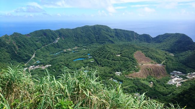 青ヶ島への交通手段は、<br />・ヘリコプター（愛らんどシャトル）<br />・フェリー<br />の２つ。<br />フェリーは就航率50%と難易度が高いため、<br />ヘリコプターで行くことに（結局台風に当たり最終的には八丈島から脱出できませんでしたが(^^;）。<br />ただ、こちらのヘリコプター、就航率90%と比較的高いのはいいのですが、座席数が9席のため、いかんせんチケットが取れません。<br />搭乗日の１ヶ月前の同日朝9時から購入できるのですが、電話が全くつながらない。<br />ぴあやローチケに朝10時からかけても繋がらない、あの状況と同じ。<br />Web予約もできますが、なぜか受付開始が12時からなので、9席しかないため12時の時点ではほとんど完売のよう。<br />私の場合は電話がわりとスムーズに繋がり購入できました。とはいえ、復路分は20分かけ続けてラスト3席で予約できたので、結構危なかったのですが、、、。<br /><br />八丈島に無事に到着後、<br />青ヶ島の民宿の女将さんから<br />「八丈島に朝着いたら必ず電話して！」<br />といわれていたので<br />愛らんどシャトルに乗る前に何度もかけたが繋がらず。<br />5回かけてようやく繋がりてっきりヘリポートまで迎えにきてくれるのかと思ったのですが、<br /><br />「あら、そう。着いたら坂道を下って登って５分くらいのところにあるから。じゃあ」<br /><br />と。<br />色々な人のブログや書き込みに、車で迎えに来てくれました、と書いてあったのですが、<br />頼み込む間さえなくガチャ切り(^^;<br />大丈夫かな？青ヶ島、、、<br />と思いながら、恐る恐るヘリに搭乗しました。<br /><br />ヘリの座席は空港リムジンバスくらいの狭さで、シートベルトは若干古く、シートも足元もお世辞にも綺麗とはいえない状態でしたが、<br />それはそれで風情？があってよい、と思えば全く気になりません。<br />必死に予約したわりには、ヘリコプターは最も乗りたくない乗り物のひとつでしたが、<br />いざ乗ってみると、景色はいいし、<br />外の風も隙間から少し入ってきて気持ちいいし、意外とプロペラの音が心地いいし（騒音だと思う人のほうが多いくらいうるさくはありますが(^^;）、<br />八丈島→御蔵島までヘリで行くのもいいなぁなんて思いながら、<br />あれだけ怖がっていたのに途中うたた寝するくらいの乗り心地でした。<br /><br />無事にヘリポートに着き、徒歩で民宿に向かおうとしたら、<br />私以外の乗客はみな迎えが着ていました。<br />青ヶ島はほとんどが坂道で険しく、宿は近くても行くのは結構大変らしい上に、この日は猛暑日で午前中から35度を余裕超え。<br />ヘリポートの待合室には手書きのざっくりとした地図しかなく(笑)、<br />縮尺と距離も正確かどうか怪しく、そもそもヘリポートの形もざっくり過ぎてどちらの方角へ進めばよいのかも迷う。<br />とりあえず道にでて、<br />「やっぱり頼るところはGoogle mapか、、、」（←とはいえ青ヶ島の道の半分は載っていないのですorz）<br />と携帯をいじり始めたら、<br /><br />「どこまで行くの？乗っていきます？」<br /><br />と、青ヶ島村の町役場の女性が親切に声をかけてくださり、図々しくも２つ返事で乗せていただきました。<br /><br />「５分とはいえ、こんな坂道をこの炎天下の中歩いていたら熱中症になっちゃいますよ！」<br /><br />と同情&amp;注意される(^^;<br /><br />「徒歩で地熱サウナに行くのは難しいですかね？」<br />「そうね～。今日のこの天候で1時間半もこのアップダウンの急な坂道を行くのはあまりおすすめできませんよ。島全体がこんな坂道ばかりですから、周遊10キロとはいえ、足腰に絶対に来ますから」<br />「じゃぁ、宿のかたにお願いするか、近場の山を登ったりしてのんびりするのがいいですかね」<br />「もう少し涼しければいいけど、この天気だとやめておいたほうがいいですね」<br /><br />（続く）