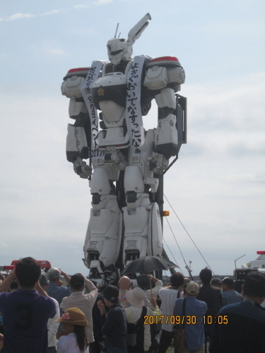 早めに茨城空港へ到着、９月３０日（土）は空の日イベントを開催していました。チェックインまで時間がありましたので一<br />寸覗いて見ました。巨大な機動警察パトレイバーが運搬車両の上で起き上がるのが圧巻でした。<br />空の日とは（イベントパンフレットより）<br />民間航空再開40周年にあたる平成 4 年（1992年）、より多くの皆様に航空に対するご理解と関心を高めていただくとの趣旨<br />により、9 月20日に「空の日」、9月20 日～30日に「空の旬間」が設けられました。<br />