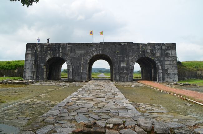 今回のヴェトナム訪問では、ニンビンでチャターしたタクシーでホー王朝の城跡を先に訪れたが、紙面の都合上先にチャンアンの景観関連遺産について書いた。この旅行記でホー王朝の城跡について、またハノイへの帰途で利用したヴェトナム国鉄についてご紹介しておく。<br /><br />ホー王朝の城跡は、1400年にベトナムに誕生したホー王朝の遺跡である。ホー王朝は14世紀まで栄えた陳朝が勢力を失い乱れる中で、勢力を伸ばした胡季犛が陳朝を倒し、自らが皇帝として即位した。しかし粛清と簒奪を繰り返したため人民の信を失って、陳朝の復権とその皇族の即位を要求した明と対立し侵攻されて、あっけなく7年で没落した。しかし短い期間に10～20トンもある巨石を積み上げ、巨大な城を構えた。現存しているのは四方の城門だけで、残念ながら城郭の建屋は残されていない。城壁の内部は水田になっており、牛がのんびりと草を食んでいた。<br /><br />城門の隣に資料館が併設されており発掘された城郭の一部や復元模型などが展示されている。ここでオークランド大学とハノイ大学で考古学を専攻し、ヴェトナムの世界遺産についての論文を作成中だという研究者のNamさんからインタビューを受けた。私が既に200ヶ所以上の世界遺産を巡っていることを話すと、質問責めにあってしまった。時間が限られているので早々に切り上げたかったが、ヴェトナムの世界遺産を世界に紹介したいという熱意にほだされて、欧米亜の印象に残った世界遺産についてその保存や紹介、展示の方法についてかなりの時間会話を交わした。彼とはFacebookで繋がっており、論文完成時には一報頂けることになっている。<br /><br />さて、ニンビンからハノイへの移動にはヴェトナム国鉄を利用、前日に予約を入れておいた。この区間は日に6便しかなく、地元の人だけではなく海外の旅行者の利用も多いため常に満席状態であるという。料金は86,000ドン（約430円）と格安で、ディーゼル機関車が客車を牽引する、日本にはほとんどなくなってしまった列車編成で、移動時間は前日利用したリムジンバスの倍の2時間30分ほどかかるが、旅情を掻き立てることこの上ない。隣に座った女性は日本に行ったことがあり片言の日本語を話し、日本語を教えてほしいというので、時間の許す限りお相手をした。この6便のうち5便はホーチミン・シティから約30時間をかけてやって来るそうで、鉄道ファンには人気の路線であるというのも頷ける。<br /><br />ヴェトナム国鉄の総延長距離は約2,600kmと日本の約10分の1、国土面積が日本の約90％であるのに比べて鉄道の発達度は高くはない。全線非電化でゲージはタイ、マレーシア、ラオスなどと共通の1,000mm、日本の在来線の1,067mmより更に狭く高速化は望めない。ほとんどが東ヨーロッパ製のディーゼル機関車で500馬力、最高速度50km/hと性能は低い。近年ベルギー製、中国製が導入され、最高速度は70km/hに改善された。路線は1975年まで続いたヴェトナム戦争で大きな被害を受けたが、戦後、統一鉄道と呼ばれるハノイ－ホーチミン・シティ間1,726kmは最優先で整備が進められた。少なくとも小生が乗車したニンビン－ハノイ間はPC枕木を使用した近代化された線路で、恐らく最高速度は70km/h程度で走行していた。ホテルのフロントでも確認したが時間は非常に正確で、単線でゆっくりと走ることを考慮しても、ヴェトナム人の几帳面さを象徴していると思う。将来は高速鉄道建設の計画があり日本への協力も要請されたそうだが、需要とコストの点で実現は課題が多いことだろう。<br /><br />最後にハノイ・ノイバイ国際空港について。日本のODA支援により国際線新ターミナルは大成建設が施工し2015年1月に開港、旅客処理能力は、これまでの年600万人から1600万人となった。ガラス張りの近代的ターミナルビルは以前の社会主義国的な薄暗さを一新させてくれ、レストランや免税店なども以前とは比較にならないほど華やかになった。ただハノイ市へのアクセスは相変わらずタクシーが主であるが、2016年から運行を開始した新型のオレンジ色の86番路線バスは30,000ドン（約150円）と他の路線バスの倍以上の値段だが、約30分間隔、所要時間約50分でハノイ駅に直行し最もお勧めではある。