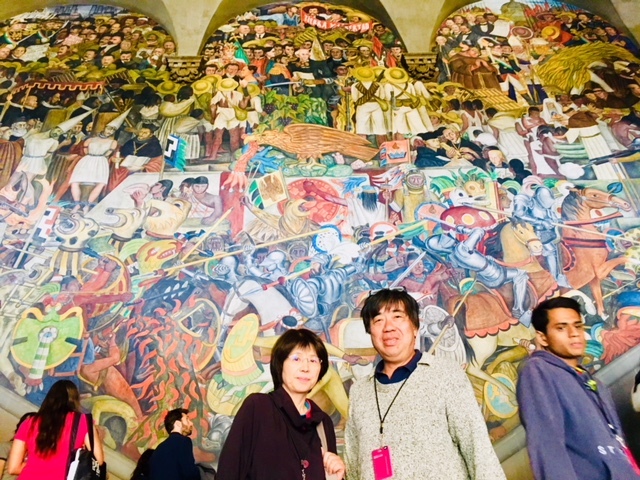 皆様こんにちは!ウォータースポーツカンクンの店長吉田です。本日は、昨日につづいてメキシコ市内観光のご案内のご報告です。こちらのブログは弊社のHPにリンクさせていただいておりますので、店長日記スタイルは控えさせてもらっていますが、お許しを(笑)<br /><br />さて、本日は、メキシコシティ市内観光のご案内をやってまいりました。カンクンと違いメキシコシティは歴史のあるメキシコの文化と歴史の中心都市です。人口は2500万といわれカンクンの20倍以上。。。大都会の名をほしいままにするこのメキシコシティは、大自然に溢れるカンクンとき真逆の文化歴史に溢れています。<br /><br />であるが故に、深い知識も当然必要になります。今回、ご案内させて頂きましたお客様にもメキシコの歴史がこんなに興味深いとは思っても見なかったとおっしゃっていただきましたが、学校で学ぶ世界史などにもこうした中南米第三国の歴史というのはさらっと触れられるだけで、あまり詳しく学ぶことはありませんから、余計に新鮮に感じるのだと思います。<br /><br />だからこそ、テストの為に苦しんで暗記した記憶があるとちょっと抵抗がある世界史でも、メキシコに来ると、こうした元々のベースがないので、素直に聞く事が出来、歴史というものを純粋に楽しむ事が出来るのかなと思います。<br /><br />というわけで、今回は写真の方で、ツアーの流れを見ていただくことにしましょうか。<br /><br />深い知識がないと、このメキシコシティのガイドは出来ません。例えば、国立宮殿に展示されるデイエゴリベラの大作「メキシコの歴史」などもそうですが、こういった文化的な芸術作品ともなると付け焼刃では到底太刀打ちできません。<br /><br />何度も目にしてご案内しているこの作品でも、毎回、このリベラの壁画からは発見する事が多いです。それがまた楽しくもあり、芸術としても鑑賞する楽しみでもあるわけですが。。。<br /><br />因みに、このメキシコの歴史という作品は中央のメキシコの国旗を髣髴とさせる鷲とサボテンのモチーフを中心に縦軸と横軸に立体的にモザイクのように組み立てられているわけですが、それは彼がキュビズムに影響を受けていたからという点では誰しもが納得するところです。<br /><br />では、、何故、中央の鷲がヘビではなく、アトル・トラチノリを咥えているのだろうか??となると、簡単には分からないのではないでしょうか?<br /><br />そもそもアトル・トラチノリとは何なのか?!といったところから始まるわけですから、なかなか一筋縄ではいきませんよね。<br /><br />こういうことはガイドブックには当然書いていません。だからこそ、ガイドを雇う意味がここに存在しているわけです。<br /><br />適当な解説をするガイドも非常に多いです。メキシコ人のガイドでもです。リベラは、この壁画を描き上げる為に、先住民の文献や歴史や芸術文化を全て学びなおしたといわれています。<br /><br />だからこそ、彼の作品には嘘がなく、作品から学ぶ事も非常に多いわけです。<br /><br />先住民の姿がときにデフォルメされていても、そこには壁画運動の目的である、識字率の低い時代に大衆に壁画をもって教育するという使命が存在しているからこそ、歴史に忠実にすばらしい作品を残してくれている。<br /><br />そんな作品を存分に楽しむにはそれなりに、彼に負けない知識が必要であり、言ってみればこの作品を前にする度に、自分のガイド力を試されている気になってくるわけですね。<br /><br />そして、お客様と共にこの作品を楽しむ。リベラが伝えようとした謎を解読していくという謎解きの面白さもあるわけですね。<br /><br />芸術作品の面白さは、この目に見える部分をそのまま感性で楽しむというだけではなく、知的好奇心をも満たしてくれる遊びも存在している。だからこそ、芸術は楽しいのです。<br /><br />そして、オチとしては、この作品の向かって左の部分、ここはメキシコの未来と題名が付けられていますが、トロッツキーなど思いっきりメキシコの未来の理想の姿が共産主義礼賛になっているのは、時の時代を反映しているとは言え、それは壁画運動の目的をかなり逸脱していないか?!なんて突っ込みを入れたくもなってくるところが、また面白いのです(笑)<br /><br />因みに、リベラはその後共産党を離脱していますから、彼はその後この作品をどういう目で見ていたのかな。。。なんて思いを馳せると、そこに芸術家の人間味ってものも感じられてまたまた楽しみも増すわけですね。<br /><br />因みに、このツアーでは、その後ビジャスアルテス宮殿の壁画もご案内しますが、ここにはクロスロードの男という、これまたディエゴ・リベラの大作が展示してあるわけですが、これもまた、目一杯左よりの作品で実に面白い。<br /><br />もともと、ロックフェラー二世に依頼されて描きあげた作品らしいですが、よくもまー、資本主義の権化たるロックフェラー家に、共産主義礼賛の作品を描き上げようと思ったものだと感心してしまうわけです。<br /><br />芸術は人をも変えられると信じたのかもしれませんが、当然ですが、完成と同時にロックフェラー2世の逆鱗に触れ、その場で破壊されたというわけで。。。この作品は、失意のままメキシコに戻った彼が、再度壁画運動の依頼を受けたのをいいことに、同じテーマの似た作品をここに書き上げたということで。。。懲りない奴。。。というリベラの愛嬌ある顔が目に浮かんでくるわけですね(笑)<br /><br />他にもシケイロスの新民主主義の幕開けなども見所ありますが、この作品にしても元々は民族の独立と自由というタイトルで描き始めたのに、途中で第二次大戦が終了してしまったため、急遽ナチスの兵士の死を付け足してタイトル「新民主主義の幕開け」と変えたなんてエピソードを聞いたりすると、また面白いなーーとかんじてしまつたり(^^)<br /><br />なので、この大胆な両性具有の人物は、頭にフリジア帽をかぶっているわけですが、新民主主義の幕開けというタイトルにそぐわない、ちょっとアンバランスな内容に仕上がってしまっていたりします(笑) フリジア帽はフランス革命の革命の象徴ですからね(^^)<br /><br />メキシコの町の中にはこうした壁画以外にも彫刻など大きな作品が沢山展示されて実際に触れて感じるという彫刻の良さなども楽しむ事が出来ます。レオノラ・キャリントンの作品などは人類学博物館の横の通りに沢山展示してありますし、有名なセバスチャンの「馬」などレフォルマどおりにドンと置かれたりして楽しいですよね。<br /><br />因みに、このセバスチャンの作品は、カンクンのホテルゾーン南入り口にも赤い花のようなモニュメントとして展示されています。カンクンにきたら、あー、これはセバスチャンの作品だねーと是非眺めてみてください。<br /><br />歴史に芸術、このアカデミックな世界に触れながらも、人間味溢れる芸術家の人となりに作品を通じて触れること。これこそが、メキシコシティの面白さでもあり、そしてその歴史が未だに生きているのが特徴なのです。<br /><br />というわけで、店長お気に入りのおススメレストラン、OPERAに昼食はご案内となりました。ここのお店の詳細は以前ブログで書きましたのでそちらに譲らせていただきますが、本ツアーでは、こちらかもう一つのシティで一番古いレストランの方にご案内さてせいただいております。<br /><br />どちらも歴史が息づくすばらしい名店です。<br /><br />今回は時間の都合で全体的に遅くなった為、最後のラテンアメリカタワーは夜景となってしまいましたが、これはまたこれでとてもすばらしい思い出にしていただくことが出来たと思います(^^)<br /><br />皆様も、シティの歴史を肌で感じたくなったら是非店長吉田にご連絡くださいね。そんじょそこらのガイドとは違う力を発揮させていただきますので(笑)<br /><br />素敵な一日を!!<br /><br />店長吉田でした。<br /><br />