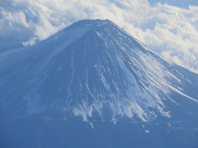 一週間の東京滞在の帰り便はジェットスター成田発福岡行。今日１２月13日の午後1時半発の便だ。福岡往復便だが、帰りは窓際席になった。それならとデジカメを手元に置いて離陸。東京近辺はいい天候なのだ。<br /><br />九十九里浜や東京湾を見下ろして、数枚撮影。進行方向左側の窓なので、もろに日光が差し込んでくる。雲が増えてくる。そろそろと思って左窓から前方を見ると富士が見えてきた。雲はあるが、富士が見えるではないか。。。<br /><br />何しろ、今年は葛飾北斎の富嶽三十六景を中心に1年が過ぎているといってもいいくらいの北斎に引き付けられた一年なのだ。今回の東京滞在中も国立西洋美術館の「北斎とジャポニスム」展を見てきた。内部の写真は一枚もない。。。借り物を展示するだけの空しい日本的な美術展なのだから、写真など撮影できるはずもない。北斎に影響を受けた西洋の画家達の作品が、え？と思うようなものまで並んでいて、まるで、北斎の絵をみんな真似たとでも言いたそうな展覧会だった。影響を与えたのは事実だろうが、影響を受けたかもしれない作品を次々見ても、フーンと思うだけだ。北斎漫画のような出版物からの北斎の絵の複製が展示してある例が多かった。それでも、北斎の浮世絵版画もかなり揃っていて、そこは見どころだった。この前の大阪のあべのハルカスの北斎展もそうだが、写真は撮れないので、沢山見たなというだけの記憶だが。。。富嶽三十六景の中の作品も今回あったが、あべのハルカスのほうが充実していた。それでも、北斎は相変わらず海外から借りてこないと状態のいい作品はなかなか見れないという実態を意識させられた。<br /><br />ジェットスターのいい席が取れたお陰で、北斎の富嶽三十六景の写真はないが、帰りに撮影した富士の写真を、デジカメ版富嶽三十六景と称して、並べたくなった！北斎を世界的天才と信ずる私としては、北斎を茶化す気はまったくないが、北斎の富嶽三十六景が世界の美術愛好者に知れ渡っていることを祝いたい気分はある。富士山の迫力を伝えたい気持ちは、北斎の富嶽三十六景の好きな私のオマージュということにしたい。それをアホクサイ（a-hokusai)と思う人はいるだろう。<br /><br />一枚目は富士のズームアップ。<br />撮影情報：1/640 秒。 f/5.6 47.552 mm<br />（Canon PowerShot SX710 HS）<br />