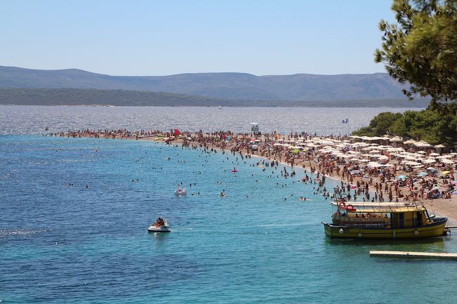 夏にクロアチアのスプリトとアドリア海に浮かぶブラーチ島に行った旅の記録、後編。<br /><br />スプリトで2泊した後、後半はブラチ島のビーチリゾートBolに5泊6日滞在。<br /><br />Bol(ブラチ島)はこんなところ:<br />・スプリトから船で1時間弱、日本の種子島より少し小さいぐらいの島<br />・『黄金の角』と呼ばれるズラトニ・ラットビーチが人気<br />・日本人含めてアジア人観光客が少ない(今のところ)<br /><br />スプリトからブラチ島へ出発: <br />朝、スプリトのホテルを出発。少し雨が降ってきそうな雲行き。まずは前日にツーリスト・インフォで聞いておいたフェリーチケット売り場へと向かってみる。場所はディオクレティアヌス宮殿前のレンタカー屋が入っている建物の中。先客も少なくすぐさまブラチ島のSupetarまでのフェリーチケットを購入。その先の埠頭のところにあるチケットセンターでは結構並んでいたので、ここでチケットを買っておいたのは正解だった。乗船するフェリーが停泊していたのは港の一番奥にあるドック。ディオクレティアヌス宮殿からだとそこそこ距離があり、歩いて10分かかった。<br /><br />表紙写真:<br />「黄金の角」と呼ばれるズラトニ・ラットビーチ