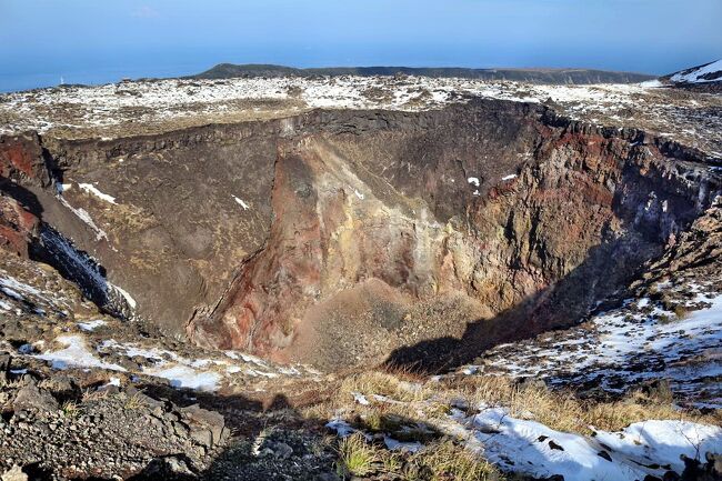 今年は伊豆大島の三原山噴火から32年目・・・三原山には一度登ってみたいと思っていたので、友達と2人で東海汽船のツアーに参加しました。<br />当初は１月23～24日の予定でしたが、前日に関東地方に降った大雪の関係で催行中止になったため、２月８～９日の日程で再チャレンジ。<br />今回の雪は伊豆大島でも珍しい大雪で、標高758mの三原山にはまだ雪が残っており、あまり経験できない雪山登山となりました。<br />三原山ハイキングの後は、大島公園で開催中の「椿まつり」を楽しんだ後、ジェット船で竹芝桟橋に戻るというコースで、一泊二日のハイキングツアーは終了。<br />写真は、三原山の最高地点から見た山頂の中央火孔・・・1986年の大噴火を思い出させる圧巻の眺めです。