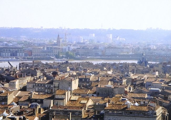 10年前のボルドー旅行の写真が今頃出てきました。ワインが好きな母親とサンテミリオンツアーに行く目的でボルドーへ行ったのでした。実はうちの父親はソムリエの免許を持っており(職業とは関係ない)ワイン好き一家で妻と僕と母親となぜかおばさんの4人でボルドーに行ったのでした。なので全くのボルドーメインでパリはちょっとしか出てきません。ただパリもボルドーも美食でした。パリもボルドーも朝のクロワッサンから日本とは違ううまさでした。ワインはおいしかったのは言うまでもありません。パリボルドーはTGVで移動車窓もよかった。ボルドーは世界遺産もあり広場も素敵でした。クラシカルでちゃんと小さくまとまっているいい町でした。<br />ブルス広場<br />ボルドーの広場の中でも最も人気のある撮影ポイントになっているブルス広場は、18世紀に20年の歳月をかけて造られました。この広場の完成によって何世紀もの間、街砦に閉ざされていた中世のボルドーは終わりを告げたのです。1720年から地方長官ブシェは、ロワイヤル広場を造り、街砦を壊すことでボルドーをガロンヌ川に向けて開かれた街にしようと市吏員や高等法院の評定員に働きかけていました。国王ルイ15世の主席建築家?ジャック?ガブリエルにこの仕事を任せるという彼の選択が決定打となりました。マスカロンで飾られ鉄細工が施された建物が並ぶ、角を落とした長四角の広場は、古典主義様式の都市の誕生に不可欠だったのです。広場の中央には、当初王の騎馬像が飾られましたが、大革命の後は短期間ナポレオンの像に換えられ、その後1869年からは三美神の噴水が置かれています。<br />水の鏡 (ミロワール?ドー) <br />ブルス広場の正面、税関吏岸quai de la Douaneとルイ13世岸quai Louis XVIIIの間にあるのが、景観作家のミシェル?クラジューによる壮観な水鏡?ミロワール?ドー。鏡のような水面と霧に包まれる空間が交互に出現します。.<br /><br />花崗岩の巨大な敷石の上の深さ2㌢の水が織りなす規則的な変化が空間を魔法で包み、子どもの水の遊び場、恋人たちの夢想の場、暑い季節には足先を水にひたせる憩いの場…と様々に変容させます。<br /><br />ガロンヌ河と18世紀の建築物の間にあって、ボルドーで一番の撮影スポットとなったミロワール?ドーは、今や現代の世界遺産です。皆様もぜひ撮影して、ボルドーから世界中のお友達に美しい水鏡の写真を発信してください。<br />またさっき述べたようにパリもボルドーも朝のクロワッサンからして違う超美食の街です。ここまで美食の国はベトナムくらいしか他は思いつきません。ボルドーでは予約していたレストランに行きました(英語メール予約です)。ボルドーのGRAVELIERです。http://www.gravelier.com/<br />ここは、ミシュランのナイフフォークマークがいくつか、そしてビブ・グルマンマークもついているお店です。<br /><br />ビブ・グルマンマークは、コストパフォーマンスに重点をおいた評価で優れたお店に付けられるマークで、ミシュラン2008年版のボルドーではこの1店しかないようです。<br />このお店のシェフは、Yves Gravelierさんという方、たぶん奥さんの Anne-Marie Gravelierさんは、有名なシェフの Pierre Troisgrosさんの娘さんだそうです。<br /><br />お店はトラムC線の駅、たしか cours de Verdun か、place p.doumer の近くにあります。<br />立地もよく明るい雰囲気グラスワインも料理もデザートも超おいしかったです。<br /><br />ボルドーワイン<br />ジロンド県全域にわたる地域で「ボルドー」を名乗ることができ、この一帯は世界的に最も有名なワイン産地の一つである。ここで産出される赤ワインは、クラレット/クレレ(Claret)とも呼ばれる。また、白ワインについてもソーテルヌの甘口な貴腐ワイン、ソーテルヌ・ワインなどがその高い品質で知られる。<br />ボルドー産の赤ワインに使用されるブドウは、カベルネ・ソーヴィニヨン、カベルネ・フラン、メルローといった品種が中心で、適度な酸味と甘みが溶け合い、その繊細な味わいから「ワインの女王」と称されている。ボルドーでもサンテミリオン地区で生産される赤ワインにはメルローの使用割合が多くなり、また違った味わいを持っている。<br />一方、白ワインではソーヴィニヨン・ブランといった品種が多く使用される。しかし、ソーテルヌ地区で生産される甘口の貴腐ワインにはセミヨンが使用される。<br />まあボルドーワインといえば赤ワイン特にサンテミリオンが有名ですね。ちょっとタンニンの強いものは匂いのあるラムやウサギや野鳥などにあいますね。<br />ボルドーでは、古くから品質にしたがってワインの格付けが行われており、特に1855年のメドック地区における赤ワインの格付けが有名である。<br />ボルドーですが世界遺産もあり徒歩1時間圏内で歩きまわれるいいクラシカルな町でした。カヌレもボルドー名物おいしかった。<br />サンテミリオンワインツアーも素敵でした。<br />フランスはパリモンサンミッシェルシャモニーに他は行きましたがボルドーはこの中では一番美食の街で歩きやすい町でした。ただシャモニーの絶景には負けるかなでももう1回行きたいのはボルドーです。パリは最近治安が良くないのでついでに寄るくらいがちょうどいいかと思います。ただセーヌ川ポンヌフ界隈は好きです。