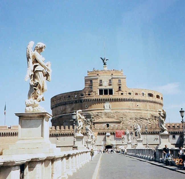2002年5月に出張帰りにローマに立ち寄った際、バチカン市国を訪問する機会を得た。まず、バチカンの軍事的砦となっているサンタンジェロ城を見て回った。建物の美しい姿は見とれるほどである。それから、サンピエトロ広場に出て、サン・ピエトロ大聖堂を目の前にした。広場では、日曜だと正午にローマ法王が皆の前に姿を見せるのである。今回はたまたま日曜であったので、法王の姿を拝見することができた。宮殿の中には、システィーナ礼拝堂があって、有名な作品を見ることができた。ここではやはり、ミケランジェロの「最後の審判」が見逃せない。<br /><br />写真は、サンタンジェロ城