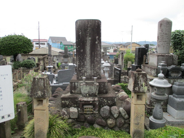 吉井山・玄太寺（げんだじ、群馬県高崎市吉井町吉井）は天正１８年（１５９０）小田原戦役後関東に入府した徳川家康に従い２万石の所領を与えられ当地に陣屋を構えた譜代大名菅沼定利（すがぬま・さだとし、生誕不詳～１６０２）によって創建された曹洞宗の寺院です。<br /><br />定利は東三河における山家三方衆（やまがさんぽうしゅう、設楽郡を中心とする奥三河に割拠した作手の奥平氏、長篠の菅沼氏、田峯の菅沼氏を中心とする有力土着領主）のうち、惣領家である田峯菅沼氏の出身で、戦国時代の奥三河は南進する武田氏と西進する今川氏の草刈り場で各地領主は自勢力保全のため、双方の勢力の変化に対応してある時は武田氏、ある時は今川氏と主家を変えていました。<br /><br />永禄３年（１５６０）今川義元が桶狭間合戦で殺害され、今川氏から独立し西三河を統一した徳川家康が奥三河に侵攻、当地域では武田氏と徳川氏のいずれかに属するかの綱引きがおこなわれるなか、元亀２年（１５７１）惣領家田峯の実父菅沼定吉が武田氏に与したことに異を唱え、定利は庶流に当たる菅沼定盈（すがぬま・さだみつ、１５４２～１６０４）に合流し徳川方に属することになります。<br /><br />武田氏滅亡に伴い武田氏に与した宗家菅沼定吉らは没落、田峯菅沼家の名跡を継いだ定利は信濃国の領有化実現をめざす家康命により同国伊那郡に入部し定利出身の旧田峯菅沼の部将勢力を掌握して同地における勢力安定化に務め、更に秀吉に臣属した越後上杉氏との国境設定交渉に携わるなど重要な使命にあたります。<br /><br />慶長５年（１６００）関ヶ原合戦で定利は秀忠軍に従い真田昌幸の上田城攻撃に参戦、慶長７年（１６０２）に死去、遺体は当時菩提寺とされた仁叟寺（じんそうじ、吉井町神保）に埋葬されますが、１５０年後菅沼一族後裔で三河国新城三代藩主の菅沼定用（すがぬま・さだもち、１７０１～１７６８）によって玄太寺に改葬され現在に至っています。<br /><br />尚定用は上述の田峯家の庶流にあたる野田菅沼氏系で、六代定昭（さだあきら）に嗣子なく２３歳で死去、丹波亀山の3万8千石が無嗣改易となります。しかしながら幕府は定盈以来の忠勤の家系を絶やすことを惜しみ異母弟定実（さだざね）に遠祖の地である設楽郡１万石を与えて菅沼家を復活させる温情の処置がなされます。<br /><br />大名格を有する１万石の定実（さだざね）は弟に知行3千石を与え、自らは７千石の交代寄合の身分に収まります。定用は定実から数えて三代目ということになります。<br /><br /><br />定利墓石の傍らに設置の説明板には下記の通り記載されています。<br /><br /><br />「　町指定史跡<br />　菅沼定利墓碑　　　　指定年月日　　平成6年7月27日<br />　　　　　　　　　　　所　有　者　　玄　　太　　寺<br /><br />天正１８年（西暦１５９０）北条氏が滅びると、徳川氏が関東にはいり、今の吉井町から藤岡市にかけては平岩地区を除いて家臣の菅沼定利（すがぬまさだとし）の所領となった。菅沼定利は今国道となっている吉井町の大通りを整備し、吉井の宿場を造った。そして慶長５年（１６００）自分の菩提寺として玄太寺を創建した。関ヶ原の戦いのあった年である。定利は慶長７年（１６０２）に亡くなった。<br /><br />墓碑には「隆興院殿五位下前上　吉井領主広山玄太大居士　、慶長七年十月二十二日、菅沼織部政限定要塞収保焉、宝暦六丙子冬」とある。宝暦６年は１７５６年で、菅沼定用（さだもち）は徳川家譜代の家臣である。<br />　　　　　　<br />　　　　　　　　　　　　　　　　　　　高崎市教育委員会　」<br />