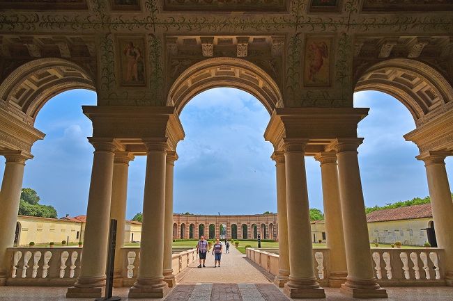 今年の春～夏の旅行シーズンは、ひとりでミラノからローマの間に点在するイタリアの世界遺産18個所巡りをすることになった。その動機と旅行の決定までの経緯は、このシリーズ１回目の下記旅日記をご覧ください。<br /><br />https://4travel.jp/travelogue/11378140?lid=notice_vote_travelog<br /><br />今回の旅行の行程の基本線は以下のように考えた。<br /><br />１． ミラノ～ヴェネツィア～リミニ（アドリア海沿岸）間に点在する世界遺産の街は列車で移動し、一日に１個所または２個所を訪れる。幸い、隣町までは普通列車で1時間前後の距離となっている。<br />２． 宿泊地を毎日変えて移動するか、拠点を作ってそこから日帰りをしながら世界遺産訪問をするかについては、色んな街の朝夕の風情も味わうか、大きな荷物を持っての移動を出来るだけ避けるかの選択になるのだが、結局両者共捨て難くて折衷案とした。<br />３． フィレンツェから南のトスカーナ地方の世界遺産の街は、鉄道では不便なところも多いため、フィレンツェを拠点としてそこから日帰りのバスツアー利用を多用することにする。<br />４． 特急列車・ホテル・日帰りバスツアーの予約は、すべて出発前に済ませておく。旅のスタイルについては、自由気儘に行き当たりばったりでという方法もあるが、目的が世界遺産訪問と明確であるため、一定期間にその目的を達成する方法を予め決めておくことがベターと考えた。もちろん、トラブルや悪天候のために計画通りに行かないこともあると思うが、その時には順送りにスケジュールを遅らせるのではなく、飛ばして次に向かうことで良いと考えた。ツアーであれば予め決められた予定をこなして、もし出来ないことがあっても順送りはないということと同じだ。ただ、ある程度の挽回は出来るように、所々にゆとりの行程を入れることにする。列車移動のほとんどは、予約の必要のない普通列車というのも柔軟性を持たせるのに好都合だ。<br />５． ホテル滞在を楽しむ訳ではないので、ホテルは基本的に３つ星で朝食込み１万円／泊見当とする。有名な観光地ほど高く、田舎ほど安いのはどこでも同じだが、実際にエクスペディアで予約してみると平均１万円程度に納まった。<br />６． ホテル所在地は、行程により駅前と旧市街の真ん中とを使い分けた。理由は、日によって荷物運びに便利か、街の風情を味わうのに好都合かで選んだ。イタリアの古い街は、鉄道駅から１ｋｍほど離れたところに旧市街（＝世界遺産）があるケースが多い。<br />７． フライトは、一人で身軽なこともあり出来るだけ安いチケットを選び、ターキッシュエアライン（イスタンブール経由）でミラノin/out とした。<br />８． 結局、18の世界遺産を訪れるために、３週間（18泊）の日程を組んだ。具体的には、以下の行程となる（【世】は世界遺産の略）。<br /><br />・１日目：夜成田発、機内泊<br />・２日目：朝ミラノ着、【世】モデナ見物、モデナ泊<br />・３日目：【世】マントヴァ見物、ヴェローナ泊<br />・４日目：【世】ヴェローナ見物、【世】ブレシア見物、ヴェローナ泊<br />・５日目：【世】ヴィチェンツァ見物、パドヴァ泊<br />・６日目：【世】パドヴァ見物、フェラーラ泊<br />・７日目：【世】フェラーラ見物、ラヴェンナ泊<br />・８日目：【世】ラヴェンナ見物、ラヴェンナ泊<br />・９日目：ラヴェンナ‐リミニ移動、リミニ泊<br />・10日目：【世】サンマリノ見物、リミニ泊<br />・11日目：【世】ウルビーノ見物、リミニ泊<br />・12日目：ボローニャ見物、フィレンツェ泊<br />・13日目：【世】ピサ見物、【世】フィレンツェ見物、フィレンツェ泊<br />・14日目：日帰りバスツアーで【世】アッシジ見物、ペルージャ見物、フィレンツェ泊<br />・15日目：日帰りバスツアーで【世】ピエンツァと【世】オルチャ渓谷見物、フィレンツェ泊<br />・16日目：日帰りバスツアーで【世】チンクエテッレ見物、フィレンツェ泊<br />・17日目：日帰りバスツアーで【世】サンジミニャーノと【世】シエナ見物、フィレンツェ泊<br />・18日目：【世】フィレンツェ見物、ミラノ泊<br />・19日目：コモ湖見物、ミラノ泊<br />・20日目：パヴィア修道院見物、夕方ミラノ発、機内泊<br />・21日目：夕方成田着<br /><br />第２回目は、３日目朝にモデナから鉄道で移動し、世界遺産「マントヴァとサッビオネータ」の街のひとつマントヴァを見物した模様となる。<br /><br />＜旅メモ１＞荷物<br />今回の旅行で持って行くカバンを何にするか最初は迷った。手荷物はリュックで良いとして、大きなカバンはどうするか。家にあるのは、総長さ157㎝の10日間ツアーにいつも持っていくものしかない。ひとり旅で鉄道利用ということを考えると、一回り小さいものを購入することも考えたが、大きくても小さくてもガラガラ引っ張る必要があり、面倒なことには変わりない。結局、結構大きなトランクで行くことになったが、結果はそれほど不自由とは感じなかった。飛行機はもちろん、列車でも駅からホテルまでの歩行でも大き過ぎて困ることはなかった。<br /><br />持参の着替えは、何日分ぐらいにするか。10日間のツアーでは、いつも10日分を持参している。今回の３週間では全部持って行くことは無理なので途中洗濯することにして、８日分ぐらいの着替えを持参した。途中、上手くコインランドリーを２回利用することが出来、着替えは順調に回転した(笑)。<br /><br />持参した食料は、柿の種・あられ・イカフライ・インスタント味噌汁・カロリーメイトで、いずれも役立った。<br />