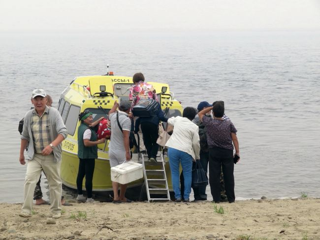 レナ川中流域にあるサハ共和国の首都ヤクーツクは、ハバロフスクやウラジオストクをつなぐ主要道路を含め、人と物の移動のために、常にレナ川を渡らなければなりません。<br />だけど、レナ川に架かる橋はありません。橋を架けるプロジェクトは、ロシアがクリミア半島を併合したときに、あちらに予算が取られ、いったん白紙に戻ってしまったそうです。<br />なので、レナ川を渡ることは、ヤクーツクの人々の生活においてとても重要です。<br />川を渡る手段は、凍結している９月末から５月始めまでは、川そのものが道路になってしまうので、それこそどこも自由に、車でも、あるいはその気になれば川幅の狭いところを徒歩でも渡るのは可能ですが、氷が溶けている間の手段は、車ごと乗り込めるフェリーや、人のみを運ぶボートが１日に数本しかなく、それを利用するしかいれません。<br />しかも、氷が溶け始める５月中頃と氷結し始める９月の上旬は、川は封鎖されてしまいます。<br /><br />今回の私の旅行では、ガイドと車付きで、ヤクーツクから日帰りエクスカーションを２本（ブルウスの谷とソツィンツィ）入れていたので、車ごと乗り込むフェリーと、人のみのボートの両方で、レナ川往復を経験することができました。<br /><br />ちなみに、ソツィンツィに行った７月13日（土）は、ヤクーツクに隣接する広大な針葉樹林（タイガ）で火事が発生していて、その煙のためにヤクーツク全域にわたって非常に視界が悪くなっていました。<br />午後になると、数メートル先は白くかすんでよく見えず、濃霧か、あるいは想像するに、昔の霧のロンドンのようなかんじでした。<br />そのため、午後は大型フェリーの運航は禁止されていました。<br />当初はソツィンツィ行きも、大型フェリーでレナ川を渡る予定でしたが、週末のフェリーは大混雑するので、現地ガイドさんの判断でボートに変更になったのですが、変更しておいて良かったです。<br /><br />その煙の影響で実は空港も閉鎖されていて、帰路のフライトに大影響を与えたことは、すでにアップした旅行記でレポート済みです。<br /><br />関連の旅行記<br />「2018年シベリア・サハ共和国ヤクーツクへの旅（１）近くて遠い国へのアクセス：定刻通りの往路とウラジオストク空港散策＆大幅遅延と初ロストバケージの帰路」<br />https://4travel.jp/travelogue/11382193<br /><br />＜2018年シベリア・サハ共和国ヤクーツクへの旅の簡易旅程一覧＞<br />7/09月　成田第１ターミナル発ウラジオストク経由ヤクーツク到着<br />7/10火　市内観光：ヤロスラフスキー北方民族歴史・文化博物館ほか<br />7/11水　市内観光：ヤクーツク地方考古学民俗博物館とマンモス博物館ほか<br />7/12木　ブルウスの谷・エクスカーション★<br />7/13金　ヤクーツク動物園＆市内観光：人形博物館と旧市街ほか<br />7/14土　ソツィンツィ・エクスカーション★<br />7/15日　４時間遅れのヤクーツク出発＆ウラジオストク経由で成田到着<br /><br />※この旅行記の対象の日に★印をつけました。<br /><br />＜2018年シベリア・サハ共和国ヤクーツクへの旅の旅行記サブタイトル一覧（予定）＞<br />7/09月　成田第１ターミナル発ウラジオストク経由ヤクーツク到着★<br />7/10火　市内観光：ヤロスラフスキー北方民族歴史・文化博物館＆ガイド付きで宝飾展示博物館<br />7/11水　市内観光：ヤクーツク地方考古学民俗博物館とマンモス博物館＆国立美術館とギャラリー<br />7/12木　ブルウスの谷・エクスカーション<br />7/13金　ヤクーツク動物園とポクロフスコの夏至祭り会場＆市内観光：人形博物館と旧市街<br />7/14土　ソツィンツィ・エクスカーション<br />7/15日　４時間遅れのヤクーツク出発＆ウラジオストク経由で成田到着<br /><br />※この旅行記の対象の日に★印をつけました。<br /><br />＜2018年シベリア・サハ共和国ヤクーツクへの旅の旅行記サブタイトル一覧（予定）＞<br />（１）近くて遠い国へのアクセス：定刻通りの往路とウラジオストク空港散策＆大幅遅延と初ロストバケージの帰路<br />（２）旧ソ連としては快適な三ツ星ホテル・ソナタと朝食<br />（３）朝食以外の食事とレストラン・カフェ編：ロシア料理やスイーツ以外の外食はいまいち<br />（４）移動編その１：市内バスと郊外行きの乗り合いシャトルタクシー<br />★（５）移動編その２：エクスカーションでレナ川を渡ったフェリーとボートの旅<br />（６）植物編：永久凍土で高く育たない白樺や白柳の街路と針葉樹林（タイガ）＆短い夏を彩る豊かな花<br />（７）動物園以外の動物：ヤクーツクの野良猫は冬を越せない＆田園風景の中の馬や牛たち<br />（８）市内編その１：燃料パイプが地上に出た工事現場のようなヤクーツク<br />（９）市内編その２：旧ソ連らしい現代ヤクーツクの町並みと人々<br />（10）市内編その３：コサック時代を彷彿とさせる旧市街や可愛い一角もあるヤクーツク<br />（11）市内編その４：身近ゆえに楽しいスーパーマーケット散策<br />（12）おみやげ編：アクセサリー買いまくり＆カタログで紹介する宝飾展示博物館<br />（13）ヤロスラフスキー北方民族歴史・文化博物館（前編）セミクジラとマンモスの全身骨格から始まって<br />（14）ヤロスラフスキー北方民族歴史・文化博物館（後編）サハ人の民族衣装や宝飾品からロシアのおもちゃやシャーマニズム展示など<br />（15）ヤクーツク大学内にあるヤクーツク地方考古学民俗博物館<br />（16）ここでしか見られない珍しいマンモス博物館<br />（17）国立美術館は撮影禁止＆代わりに写真が撮れた子供たちによる警官の絵<br />（18）２人の女流画家のギャラリーでサハ人とサハの風景画を満喫する～宝飾展示博物館の建物内にあった国立美術館分館<br />（19）夏でも氷が残る水が美味しいブルウスの谷へのエクスカーション<br />（20）ヤクーツク動物園Orto Doidu：思いがけず会えた黒ギツネの赤ちゃんたち＆ホッキョクグマのロモノーソフくんとコルィマーナさん～日本の動物園であまり見ない動物たちもたくさん！<br />（21）動物園ののどかな風景とポクロフスクの町の夏至祭り会場<br />（22）旧市街の人形博物館：平易なロシア語とジェスチャーによる館員さんの懸命な解説付きで見学<br />（23）ソツィンツィ編その１：木造建築が移設された広大なドルージュバ（友愛）野外建築博物館<br />（24）ソツィンツィ編その２：チェラプチャ村の人々の小さな夏祭り＆煙で白くかすむ幻想的な景色<br /><br /><br />詳細旅程はもう１つのブログ「まみ’s Travel Diary」に掲載しました。<br />（http://mami1.cocolog-nifty.com/<br />「シベリアのサハ共和国ヤクーツク旅行の詳細旅程とハイライト写真」<br />http://mami1.cocolog-nifty.com/travel_diary1/2018/08/post-f015.html