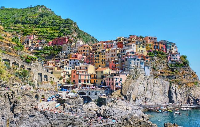 チンクエ・テッレ（Cinque Terre）とはイタリア語で「5つの土地」という意味で、文字通り5つの小さな村が、リヴィエラ海岸から東に続く海岸線に点在しています。<br /><br />この地域に人が住み始めたのは11世紀頃、もともと漁村だったわけではなく、山間の峡谷に住んでいた人々が、人口増加に伴って海沿いに進出し、5つの村に分かれて定住し始めたのだそうです。<br /><br />当初は農業を営んでいて、船で作物を運搬するため港を整備し、徐々にヨーロッパ方面に進出していきました。そして当時港町として繁栄を極めたジェノヴァと対立し、結果、戦争に敗れ、12世紀後半には、チンクエテッレはジェノヴァ領に吸収され、その後はジェノヴァの海洋要塞都市として発展・・・。<br /><br />1800年代後半に鉄道が開通し、道路も整備され、ジェノヴァの貴族達がこの地域で生産されるワイン『シャケトラ』目当てに別荘を建てるようになり、今私たちが知る、断崖絶壁にカラフルな家が並ぶとても魅力的な《チンクエテッレ》になっていったのだそうです。<br /><br />時間がたっぷりあれば、5つの村（モンテロッソ アル マーレ・ヴェルナッツァ・コルニリア・マナローラ・リオマッジョーレ）のをすべて見たかったのですが、時間の関係上、私はヴェルナッツァとマナローラとリオマッジョーレの３つの村をめぐることに・・・。すでにヴェルナッツァは観光していたので、3時間ほどの予定で残るマナローラとリオマッジョーレに向けて出発したのでした。