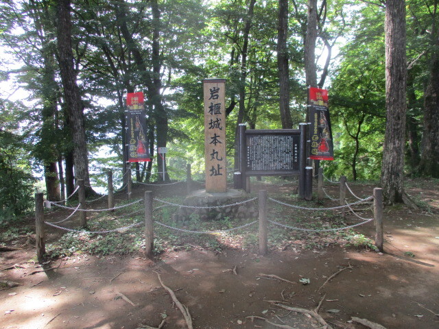 岩櫃城(いわびつじょう、群馬県吾妻郡東吾妻町原町)は東西に流れる吾妻(あがつま)川の北岸にそびえる岩櫃山(標高802m)の東側に南から北に傾斜する中腹の地に約140mほどの主郭を有する細長い連郭式の山城です。<br /><br />築城時期と築城者については明確ではありませんが一説には南北朝時代に吾妻行盛(あがつま・ゆきもり)、他説には戦国時代に武田信玄築城との説もあります。(下記パンフレット掲載は吾妻行盛築城の説で説明されています)<br /><br />いずれにせよ戦国時代に西上野攻略を企てた武田信玄の領有することとなり、その城代には信濃と上野の境目に詳しく調略の名人と称される真田幸隆(さなだ・ゆきたか、1513~1574)が任命され武田氏の攻略拠点となり、併せて小田原北条氏の東上野を含む北関東の動向並びに越山してくる上杉謙信の動き等を本国に報告する役割があったようです。<br /><br />縄張りについては次のようになります。即ち、岩櫃山頂上側に接近している主郭は狭い上段と広めの下段に分かれ、上段には「岩櫃城本丸址」と刻した石碑が建ち、下段の南側には二郭から南虎口に通ずる腰曲輪が走り、この腰曲輪からは南斜面に向けて竪堀が認められます。<br /><br />主郭には南北にそれぞれ虎口を配し、特に南側虎口は枡形門跡との案内があって正門があったと思われます。主郭の北側には狭い二郭が配されこの間には角度を伴った見事な堀切が南北に走りそのまま南方向に竪堀として落ちています。<br /><br />更に東側にはそれまでの険しさが一転、南方向になだらかに広がる扇状地があって、標柱には「中城跡」とだけ記載、詳細説明がないのでその機能が不明ながら険阻な城郭に対して不釣り合いな印象を感じさせます。<br /><br /><br />現地案内所にて入手したパンフレット「真田氏上州の拠点 岩櫃城跡」には下記の通り紹介されています。<br /><br /><br />「 岩櫃城の歴史<br /><br />岩櫃城は、年代は定かではありませんが、南北朝のころ築城されたと考えられています。城郭の規模は136へクタ-ルと上州最大規模を誇り、後に甲斐の岩殿城、駿河の久能城と並び武田領内の三名城と称されました。この城の城主として最初に名前が出てくるのは我妻太郎行盛です。行盛は南北朝時代、里見氏に攻められ吾妻川原において自害したという伝説があります。その後行盛の子千王丸(斉藤越前守憲行)が北朝方の上野守護上杉顕氏の支援によって岩櫃城を奪回し、その子孫が戦国時代までこの城を本拠として東吾妻を支配しました。<br /><br />永禄6年(1563)、武田信玄は上州侵略のため、家臣真田幸隆に岩櫃城攻略を命じました。ときの城主は吾妻太郎行盛より数えて6代目の吾妻太郎斎藤越前守憲広(基国)といわれ、堅城を利して奮戦しましたが、ついに落城してしまいました。こうして岩櫃城は武田信玄の手中に落ち、信玄は幸隆に吾妻郡の守護を命じました。<br /><br />天正2年(1574)に幸隆が世を去り、岩櫃城主には長子の信綱が収まりましたが、翌年、長篠の戦いで長綱、昌輝兄弟が戦死したため、真田家は幸隆の三男、昌幸が相続しました。その後、昌幸の長男信幸が支配し、信幸の弟幸村も少年時代をこの城で過ごしたと言われています。<br /><br />一度北条氏の支配下に置かれた沼田は再び真田氏の支配下となり、信幸は初代沼田城主となりました。岩櫃城は沼田の支城として吾妻郡統治の中心地としての役割を果たしました。<br /><br />慶長5年(1600)、関ヶ原の戦いでは、昌幸(西軍)と信幸(東軍)は敵味方に分かれました。このとき岩櫃城は信幸の叔父矢沢頼綱が城代となり、信幸方の城となっています。そして、幾多のドラマの舞台となった岩櫃城も徳川家康が発した一国一城令(元和元年(1615))により、四百余年の長い歴史を残し、その姿を消しました。 」<br /><br /><br /><br /><br /><br />