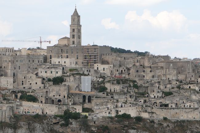 6月12日-7月9日の25泊27日、南イタリアへ行きました♪<br />観光・グルメ・海水浴をたっぷりと楽しんできました♪<br /><br />☆Vol.242：第8日目（6月20日）マテーラ（マテーラ県）♪<br />マテーラは2年ぶり2回目。<br />前回はマテーラの世界遺産地区であるサッシ地区内のホテルで2泊した。<br />2泊3日マテーラをくまなく観光しているので、<br />今回はパノラマのみ。<br />グラヴィーナ川の対岸はムルジャ公園の高原。<br />そこからマテーラのサッシ地区を全て見渡すパノラマスポットがある。<br />その代表的なスポットは「Murgia Timone」であるが、<br />もう一カ所の穴場なスポットがある。<br />それは「Chiesa Rupestre della Madonna delle Vergini」。<br />断崖にたくさんの洞窟があり、これもサッシと思われる。<br />その中に小さな教会があり、<br />それが「Chiesa Rupestre della Madonna delle Vergini」。<br />その前には小さな広場となっていて、<br />サッシ地区を渡せる展望台。<br />小さな教会を見ると、くりぬいた洞窟を利用している。<br />起源は不明であるが、1700年代に造られたものと思われる。<br />周囲にもたくさんのサッシがあり、<br />ここでも生活があったことを物語っている。<br />ここで生活しながら、対岸の美しいマテーラの町並みを眺めたことだろうと容易に想像できる。<br />ここからのパノラマは大聖堂のある東側のサッシ地区が近く、<br />大聖堂のあるサッシ風景が美しい。<br />ゆったりと眺めて♪