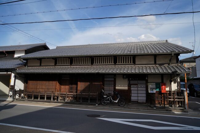 京都市伏見区深草は、全国の稲荷神社の総本宮である伏見稲荷大社の南側に位置し、京都と伏見を結んで南北に通る伏見街道に沿って広がっています。<br /><br />かつての深草は、農業のかたわら土器を作る小さな農村に過ぎませんでしたが、豊臣秀吉による伏見城の築城と城下町整備の恩恵を受け、村は大きく様変わりすることとなり、特に名所や古刹が多かったことから、参詣の旅人で大いに賑わいました。<br /><br />徳川幕府の一国一城令で伏見城が廃城されて以降、商業の町として再出発した伏見とともに発展をつづけた深草も、鳥羽伏見の戦いの戦場となり、町は焼失してしまいます。<br /><br />その後、明治３１年（１８９８年）に陸軍３８歩兵連隊が伏見に駐屯したのに続いて、明治４１年（１９０８年）には第１６師団が深草に駐留するようになり、師団司令部や兵舎の置かれた軍需産業の町として活況を取り戻します。<br /><br />京阪本線墨染駅近辺から伏見稲荷大社にかけて、南北に延びる伏見街道沿いに広がる現在の深草には、明治時代以降に建てられた京都らしい商家や町家が点在する、情緒ある町並みが続いています。