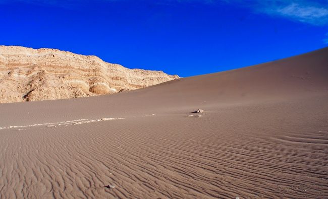 =以下、wikiより=<br /><br />....アタカマ砂漠は、アンデス山脈と太平洋の間にある巨大砂漠....全体の平均標高は約2000m（高い場所で6000m近い）にも達し、その過酷さからアタカマ砂漠への道は「死への道」と恐れられていた......日中は灼熱の太陽が照りつけ、気温が上がり、夜は氷点下まで気温が下がる.....苛酷な環境.....<br /><br />.....世界で最も乾燥した砂漠として知られており....その乾燥から晴天率が非常に高いため、世界の天文台が集中している.....<br /><br />.....南北の長さは1,000kmあり、アンデス山脈と海沿いの山脈に挟まれているため、アンデス山脈で湿った空気が遮断されるため乾燥した砂漠帯となっている....40年間まったく雨が降らなかった地域もある.....<br /><br />....不毛で岩塩や石灰の堆積層で覆われている所が多く、銅・銀・ニッケル・リチウムなどの鉱物資源に富んで....天然の硝酸ナトリウム（チリ硝石）の産出は世界最大であり....また、世界最大のリチウム産地である.....<br /><br />....実は、約5000もの地上絵がある...この地上絵はナスカのような巨大な地上絵ではなく、また斜面に描かれている......<br />---------------------------------------------------------------------------<br />そんなアタカマ砂漠への旅：<br /><br />■5/31 9:10 - 12:15 Avianca 8518便 サンパウロ→サンチアゴ<br />■5/31 16:09 - 18:17 Latam 154便 サンチアゴ→カラマ(Calama)<br /><br />カルマ⇔サンペドロ・デ・アタカマの町（by 車）<br />