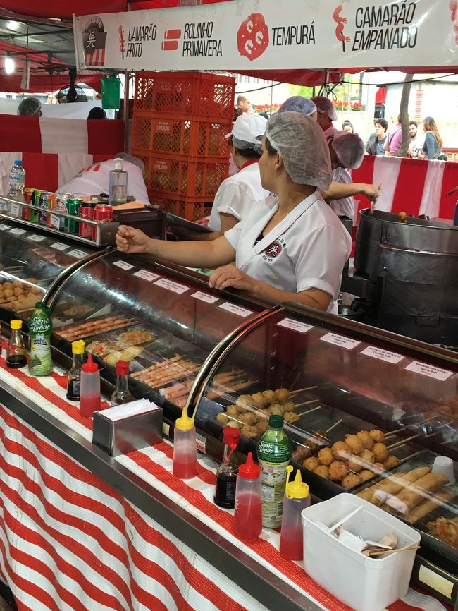 ブラジルには移住した日本人によって日本の食文化も溶け込んでいます。 日本から短期で旅行に来られると、もう笑うしかないのですが、私のようにブラジル以外の南米に長期滞在していると、もう嬉しい、神対応です。<br />サンパウロに来られるのならばリベルダージという日本人街には必ず行くとは思いますが、だとしたら日曜日に過ごせるように調整して下さい、でないともったいない。<br />日曜日には駅前にお祭のような屋台がずらっと出ます。<br />B級グルメですね。 お店の人の顔で日本語を期待してはいけません、彼らは3世4世なので無理でしょ。 それとやっぱり6割は中華系です。 ポルトガル顔の金髪青目の人も英語はほぼ期待ゼロでほんっと無理ですね。<br />日本や韓国ですら、ワン-ツー-スリーやABCくらいはいけるでしょ。 南米はブラジルも含めほんっとだめです。<br />まあそこは諦めて食を楽しみましょう！<br />まず日本人からすると100点のバラエティと70点くらいのクオリティ、そしてまともな価格です。 どこ行っても日本食って高いじゃないですか、しょうゆをお湯で薄めただけの汁にアジアで食べられてるのかなという出所不詳の麺で、はい900円ってのが普通じゃないですか。 ここはそこんとこは裏切りません。 やっぱ日本人のDNAが混じるとクオリティ高いですね！ 今日は初日なので屋台でつまみ食いばかりでお腹が一杯だったため、久しぶりの寿司(南米のクリームチーズ入りじゃないやつ)や日本の焼肉、ラーメンやトンカツは明日以降のお楽しみです。<br />仕事で来たのに、まぁいいっかww<br /><br />