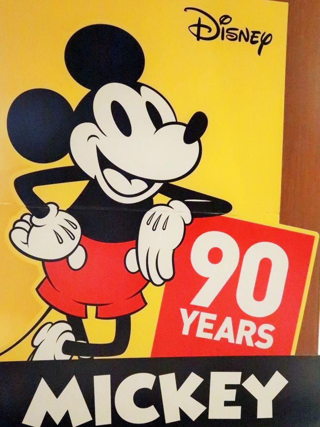 ミッキーマウス (Mickey Mouse) は、ウォルト・ディズニーとアブ・アイワークスが生み出し、1928年（昭和3年）11月18日にスクリーンデビューしたアメリカ文化のシンボル的キャラクター。<br /><br />ウォルト・ディズニー、などは『オズワルド・ザ・ラッキー・ラビット』の製作を継続しながら別作品の企画を余儀なくされ、この過程でミッキーマウスが生まれた。 「ウォルトは飼いならしたネズミをよく研究し、彼が醜いと思っていた耳・口・足などを大きくしポイントを付け1927年にミッキーマウスを考案した」という一般に知られるエピソードは架空の話である。そもそもウォルトはプロデューサーであり、アニメーターではない。 <br /><br />ウォルトは元々ミッキーをモーティマーと名付けるつもりだったが、妻リリアンの一声で現在の名前になった。その代わりにミッキーの恋のライバルであり、ミニーマウスの幼なじみとして、モーティマー・マウスが登場する。恋人はミニーマウス。愛犬はプルート。甥っ子にモーティーとフェルディーがいる。 <br /><br />実際の第1作はチャールズ・リンドバーグに因むヒット作『フィリックスのノンストップ飛行』のパロディ『プレーン・クレイジー（飛行機狂）』である。第2作は『ギャロッピング・ガウチョ』。どちらもサイレントで配給ルートも得られずまったく相手にされなかった。1928年11月18日、第3作アニメーション映画『蒸気船ウィリー』がトーキーで成功。当時ウォルトが声優を務めていた。その後映画はシリーズ化されミッキーは一躍人気キャラクターとなった。 1939年、「ミッキーの猟は楽し」以降キャラクターデザインが変更された。それまでは黒目がちであったが、この変更により白目が付いており、黒目が小さくなった。また、眉毛も無かったが、表情が付けにくいため、眉毛が付いた。<br />（フリー百科事典『ウィキペディア（Wikipedia）』より引用）<br /><br />ミッキーマウス　90周年記念　については・・<br />https://www.disney.co.jp/fc/mickey-friends/mickey90.html