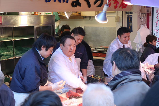 　２０１８年大晦日、築地場外市場へ行ってきました。<br />　様々な偶然が重なり、時間がぽっこりと空いたこと、飛行機のチケットがなんと１席空いていたこと、体調がいいこともあって早起きしました。<br /><br />　これまであまり築地場外市場のことは気にしたことがなかったのですが、１０月に訪れる機会があり、”ここには日本中から旨いものが集まっている！！”という勝手な確信をもつにいたり、またじっくりとお腹を空かせて訪れたいと思っていたのでした。<br /><br />　大混雑した狭い通りを人混みにまみれて歩いていると、毎年築地の初競りで大間のまぐろを最高値で落札する名物男「すしざんまいの社長」がトロを包丁でたんざくに切ってたたき売りをしていました。二千円、三千円の商品にはあっという間に買い手が付きますが、六千円となるとなかなか売れません。<br /><br />　折角やって来たのですが、お目当てのお店がビルごと壊されてなくなっていてガックリ。もう一軒目星をつけていたところでトロをアテに生ビールを二杯いただきました。通りでは、なかなかたくさんの商品が”安いよ！！”というかけ声と共に売られていましたが、結構いいお値段でした。