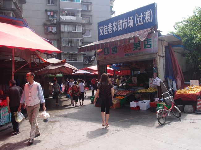 中国は以前は国有商店しかなく、生鮮三品を含む食料品販売もそうでした。鄧小平の改革開放経済政策により、80年代には自由市場が各地に生まれた現在に至っております。現在ではスーパーも発展して、食料品もここで求められますが、やはり市民は自由市場から買い求めるのが普通です。そこで、以前居住していた成都市の典型的な自由市場の一つを紹介します。<br />西南大学周辺には四つほどの自由市場（農貿市場）があります。この一つが交桂巷農貿市場です。本市場は北門から５分ほどの所にあり、交桂二巷の道の両側に店が並んでいます。回りはマンション団地で、近くにウォルマートがあります。<br />表紙写真は南側入口です。