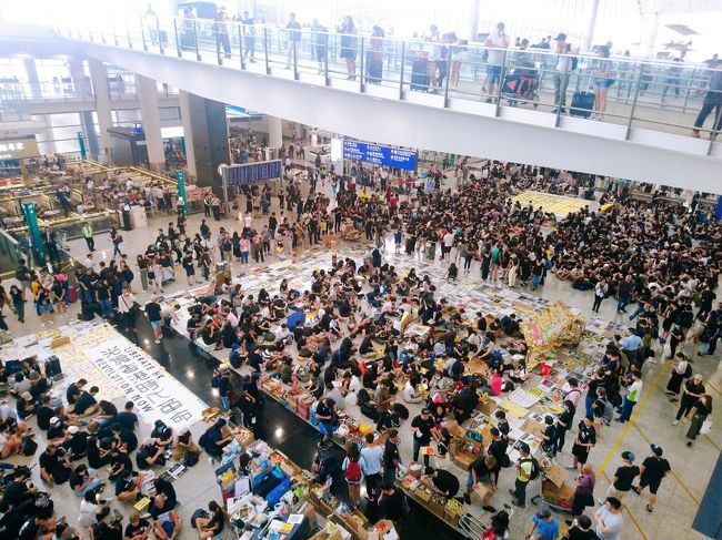 香港大丈夫?という連絡をあちこちからいただきましたので、先日利用した香港国際空港での大規模集会の様子、と、欠航情報について、書いておきたいと思います。<br /><br />あらかじめ予定されていた通り、香港国際空港では、8/9の13時から3日間の予定で大規模集会が行われていました。本来であれば、8/11に集会は終了する予定でしたが、8/11に尖沙咀の警署外で起きた女性の右目負傷事件(警察が女性の目に向けてビーンバッグ弾を打った事件。一部報道では右目を失明したともいわれているほど重傷)で、その翌日の8/12、さらに多くの抗議者が空港に訪れ抗議をしました。そのため、8/12の夕方、香港空港のすべての発着便が欠航となりました。<br /><br />航空会社は本日8/13の午前6時から対応を始めていますが、いまだほとんどのフライトが欠航している状態です。詳しくは香港国際空港の発着情報か、航空会社にお問い合わせください。<br /><br />別ブログでもまとめましたので、ご参考までに<br />https://www.travelhongkongmacau.com/entry/hkprotest0813<br /><br /><<以上8/13の香港現地時間午前8時の時点での情報です。>><br /><br /><<以下8/13の香港現地時間午後6時半の時点での追加情報です。>><br /><br />本日も13時より空港で抗議集会が開かれ、抗議者が禁止区域の入口にカートを置くなどしたため、16時よりチェックインを一時停止していましたが、17時すぎに本日のフライトの全便欠航が発表されました。<br /><br /><<以下8/14の香港現地時間午前7時の時点での追加情報です。>><br /> <br />本日(8/14)は朝からフライトの運行が再開しています。まだ少しですが欠航便もあるようですので、香港空港の発着情報を確認してから空港に向かうようにしてください。<br /><br />なお、現時点ではまだエアポートエクスプレスのインタウンチェックインは利用できない模様です。