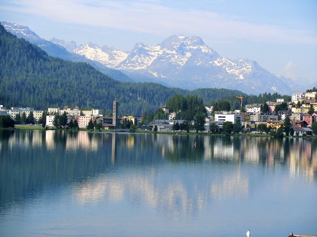 2017年の中欧の旅行記と2019年のタイの旅行記を作成中ですが、「夏旅2019」に応募することにしました。ついては現在作成中の旅行記を一時中断し、スイスの旅行記を新たに投稿することをご報告申し上げます。<br />さて、今回の旅はいつかは行きたいと念願していたスイスアルプスの旅です。<br />そのチャンスが巡ってきたのが２年前、一人参加のスイスアルプス10日間の旅でした。人気のコースだったのですでにその年の2月時点では7月の催行日は全て満席でしたが8月下旬はまだ空きがありました。<br />スイスは7月が降水量が最も少なく天候が安定しているので毎年旅行客が集中する時期です。そのためツアー料金もこの時期が最も高くなります。確か一人参加の料金で7月は46万円、8月は41万円だったと記憶していますが、その後8月の旅行は38万円に値下げになりました。スイスのツアー料金としては破格の値段です。<br />8月下旬に行こうかと検討しましたが、この時期はすでに山上は秋の気配です。高山植物はすでに無く、山上の緑は秋色に色を変え始めている頃でした。天候は7月同様安定しているようですが高山植物がなく緑のない山の景色は味気ないものに思われたので、この時はドロミテ山塊のツアーに参加して翌年のツアーの状況を見ることにしました。<br />そして2018年、ツアーの募集が始まりました。2017年と全く同じ内容でホテルも同じなのに４万円も値上がりしている。<br />7月のツアーは49万円に値上がりしました。8月下旬の出発でも44万円です。山岳列車やロープウェイ等の値上がりなのかと思いましたが、調べた限りでは料金に変動はありません。<br />もう1年待つことにした今年は一人参加のツアーが無くなりました。そのため通常のツアーの料金に一人参加の追加料金を加えると53万円です。今年は昨年比4万の値上がりでした。<br />このまま毎年４万円づつ値上がりしていけば行けなくなると思い、今年は8日間のコースに変更し旅行に参加しました。結局今年の旅行代金は昨年のスイス山岳10日間コースと同額だったので、ツアーでスイスに行かれる方は早いうちに参加されたほうがいいと思います。<br />さて、こうして参加したスイス旅行でしたが毎日が天候との戦いでした。詳しくは旅行記で説明します。<br /><br />＜旅程＞<br />7月1日　福岡ーヘルシンキーチューリッヒーサンモリッツ（泊）<br />7月2日　サンモリッツーテイラーノーベルニナ・ディアボレッツアーベルニナアルプスーサンモリッツ（泊）<br />7月3日　サンモリッツークールーサースフェーーミシャベルアルプスーテーシューツェルマット（泊）<br />7月4日　ツェルマットーゴルナーグラート展望台ーローテンボーデンーリッフェルベルクーツェルマットーマッターホルン・グレッシャー・パラダイスーツェルマット（泊）<br />7月5日　ツェルマットーテーシューシャモニーーモンブランーラヴォー地区ーユングフラウ（ウェンゲン）（泊）<br />7月6日　ウェンゲンーユングフラウ・ヨッホースフィンクス展望台ーアイガーグレッシャーークライネシャイデックー<br />　　　　ルツェルンーチューリッヒ（泊）<br />7月7日　チューリッヒーヘルシンキー（機中泊）<br />7月8日　ー福岡<br />　<br />写真はサンモリッツ湖の景色です。<br />