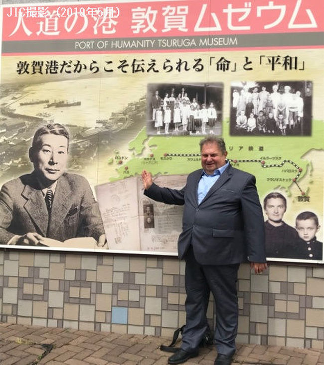 第二次大戦中、ナチス・ドイツの迫害から逃れて来た多くのユダヤ難民に本国の指示に反して日本通過ビザを発給し、6000人以上の命を救った外交官・杉原千畝については、JICインフォメーション197号(2018年7月)で紹介しました。「命のビザ」と杉原千畝の功績を伝える杉原記念館(リトアニア・カウナス)の館長、シモナス・ドヴィダヴィシュゥスさんが5月18日から30日まで来日しました。JICは、昨年「悪魔の飽食」合唱団バルト三国公演ツアーでお世話になった縁で、シモナス館長の日本訪問と滞在日程アレンジに協力しました。<br /><br /> 日本国内には、ユダヤ人難民たちが上陸した福井県敦賀港、杉原千畝の生まれ故郷・岐阜県八百津町、杉原が学んだ名古屋市の瑞陵高校、東京の早稲田大学などに資料館や顕彰碑があります。またつい最近東京・八重洲口にもセンポ・ミュージアムが開設されました。シモナス館長はそれらすべての関係施設を訪問し、また敦賀市長、八百津町長、愛知県知事、日本リトアニア友好協会(水野誠一会長)、日本リトアニア友好議員連盟(会長:中曽根弘文参議院議員)、元駐リトアニア大使白石和子氏ら多くの関係者と会って、今後の協力について懇談しました。<br /><br /> 以下、今回シモナス館長とともに訪れた杉原千畝に関係する諸施設を紹介します。<br /><br /><br />■「人道の港 敦賀ムゼウム」(福井県敦賀市)<br /><br /> 杉原千畝の発給した「命のビザ」を手にしてユダヤ人難民たちが1940年から41年にかけて上陸したのが福井県敦賀港。ムゼウムには、当時、欧亜国際連絡列車の窓口であった敦賀港の歴史や、杉原千畝の「命のビザ」、敦賀港に上陸したユダヤ人難民たちを市民がどのように受入れたかといった資料が展示されています。特に、当時を知る市民たちの証言を多数集め、着の身着のままの難民たちにリンゴを配ったり、銭湯を開放したりしたエピソードが展示されているのが心を打ちます。(なお、敦賀ムゼウムには、ロシア革命後シベリアに取り残されたポーランド孤児たち763人を1920年に日本赤十字の救援活動で敦賀に受入れた際の資料も展示されており、それらを合わせて「人道の港」という名称が冠されています)。<br /><br />開館時間9:00~17:00/年末年始以外は無休/協力金100円<br /><br /><br />■「杉原千畝記念館」(岐阜県八百津町)<br /><br /> 杉原千畝が生まれ育った八百津町に日本で最初に開設された杉原記念館です。ユダヤ人迫害の実態やホロコーストの歴史、外交官としての杉原千畝の仕事と「命のビザ」発給に至った経緯、その後のユダヤ難民たちの逃避ルート、敦賀上陸後の行方などが順を追って展示・説明されています。記念館は八百津の町を見はらす「人道の丘」展望台にあります。<br /><br />開館時間9:30~17:00/月曜休館(月曜が休日の場合は翌日)/入館料300円<br /><br /><br />■「杉原千畝広場 センポ・スギハラ・メモリアル」(名古屋市瑞穂区、愛知県立瑞陵高校内)<br /><br /> 杉原千畝は名古屋の古渡尋常小学校と第五中学校(現県立瑞陵高校)で約10年間学びました。杉原千畝広場は母校・瑞陵高校の正門西に設置されています。中央にユダヤ人家族にビザを手渡す杉原千畝のブロンズ像があり、その周囲に杉原の人間形成の時代、外交官としての任務、人道主義による決断、ビザ発給と難民たちの行路などが、セラミック・コピーで鮮明に展示されています。とくに、杉原が発給したビザの全リスト(外務省外交史料館提供)が展示されていることと、この広場が市民の誰もが自由に出入りできるオープン型の展示施設であることが大きな特徴です。