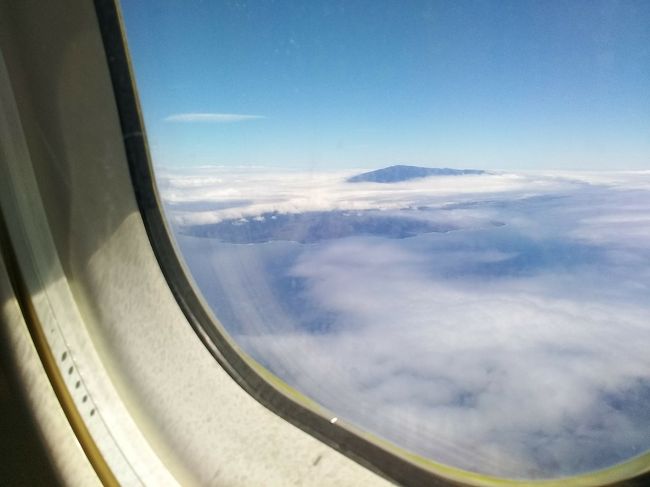 【５日目Part2】<br />ハワイ島・コナ空港からハワイアンエアラインに搭乗して一路、マウイ島・カフルイ空港へ向かって飛行しました。<br />空からマウイ島の最高峰のハレアカラ山の頂上付近が雲の上にのぞいているのが見えました。<br />右側席を予約していてその様子を見ることができました。<br />カフルイ空港はコナ空港と違って西エリアから侵入し茶色の大地(農地)を見ながら降りていきました。<br />ボーディングブリッジも沢山ありコナ空港より大きく感じました。<br />到着後、新しくできたカーレンタル会社へ連携するトラムが走っていて<br />1.到着の停車駅<br />2.出発の停車駅<br />3.レンタカー会社が並んでいる停車駅<br />三つの駅がありました<br />今年の5月15日（水）に開通し<br />従来は早くてレンタカー会社まで8分かかっていたのでトラムの開通により<br />3分くらいで行けるようになっていました<br /><br />詳細は下記URLがオープンして間近のニュースでとても分かりやすいです<br />https://www.lealeaweb.com/feature/11130