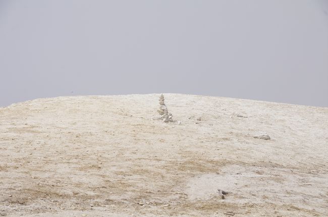 9月7日(土)、同僚との登山で山梨県北杜市の日向山(ひなたやま)を登りました。レンタカーに同乗し、標高約780mの尾白川(おじらがわ)の駐車場まで走りました。ここは日向山と甲斐駒ヶ岳の登山口であり、駐車場は混雑していました。若干雲が有りましたが、概ね良い天気でした。<br />9時40分頃の遅い登山開始であり、私達は8人でした。序盤から急な登りで、南アルプスらしいな。私は荷物をちょっとだけ重くしていました。他のメンバーは若い人ばかりで、やや速くて、ハアハア言いながら登りました。Tシャツ1枚でしたが、暑くて、滝汗となり、汗が目に染みました。途中、林道を通りました。ここから登山道に号目を示す標識が設けられています。「10/3」というような表記であり、なんだか分数が逆になっています。登りが続く道ですが、道はよく整備されており、危険は感じませんでした。他の登山客と頻繁に行き交いました。<br />緩やかになった頃、分岐が有り、一方の道を進み、すぐに三角点に着きました。1659.9mだそうです。分岐に戻り、頂上への緩やかな道を歩きました。<br />いよいよ頂上です。最初、目の前がガス(霧)で真っ白でしたが、すぐに視界が晴れました。花崗岩の風化した砂地の頂上です。眺望は雲のせいでイマイチでした。<br />見方を工夫しても、ビーチには見えません。ま、山です。ここでランチとしました。頂上はどこも傾斜が有り、平坦な所は有りませんでした。私はプリムスのバーナーとスキレットでおにぎりを焼きました。<br />食べ始めた頃、北側が晴れて、落ち着かないランチでした。山麓が綺麗に見晴らせて、八ヶ岳の素晴らしい景色となりました。八ヶ岳から続く蓼科山や霧ヶ峰もよく見えました。サントリーの白州醸造所がすぐ近くに見えましたが、そっちには下れません。近いはずの甲斐駒ヶ岳は見えませんでした。<br />荷物が砂まみれになり、カメラにも砂が付いて、心配になりました。メンバーの1人は裸足になっていました。標高1600mだそうですが、頂上の標識3つのいずれも壊れていました。<br />ここから、登った道を下りました。下りも速かった。