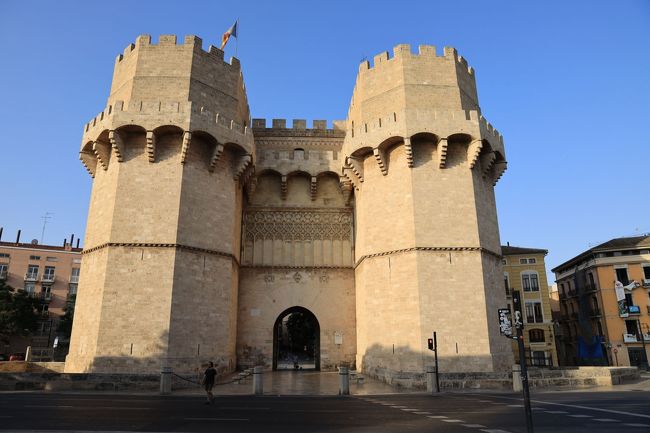３日目　19/08/04　バレンシア<br /><br />　朝8:15ホテル出発、世界遺産ラ・ロンハを見るためにバレンシア市内へと向かう。ここはパエリアが生まれた町でバレンシア・オレンジも有名。<br /><br />　市内中心部から北に位置するセラーノスの塔と呼ばれる城壁の門から旧市街へ入ると、町並が中世の雰囲気を感じさせる。路地の奥にカテドラルが見えたが、ラ・ロンハへまず向かうため細い路地を曲がりながら散策。ゴミ収集車に後ろから追われながらラ・ロンハという世界遺産に登録された旧商品取引所にたどり着いた。フラインボワイヤン・ゴシック様式で外壁もお城のような感じ。朝の観光なので、中を見ることはできず外観のみを見て、メルカード広場から大聖堂へと歩いた。<br />　大聖堂へはレイナ広場から入場することができ、内部の様子もわかった。キリスト教徒でない身にとっては、あまり教会内部の違いを感じ取ることができないのが残念。でっかいなあ、という印象でそれ以外に何を味わえば良いのかあと思ってしまう。<br /><br />　大聖堂から出て礼拝堂を覗き込み、ピルヘン広場で写真撮影タイムとなる。大聖堂の右壁にはミゲレテの塔が聳えていて、威厳を感じた。もとのバス下車場所セラーノスの塔からバスに乗り込み、トイレ休憩に向かう。モニュメントなども配置され素晴らしい施設が建てられていて、その駐車場でトイレを使った。<br />