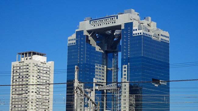 クラブツーリズム主催の日帰りバスツアーで、東海屈指の紅葉名所「香嵐峡」となばなの里イルミネーション・・・と云うツアーに参加しました。<br /><br />大阪駅西梅田バス暫定駐車場から9時半に出発し、最初に紅葉を鑑賞し、イルミは帰りがけに鑑賞するツアーでした。<br /><br />しかし・・・日帰りではなく、0泊2日間のツアーになりました。<br />家を8時前に出て大阪駅西口に着いたのが9時過ぎで、ツアーの出発は9時30分に大阪駅西梅田を観光バスで出発し、香嵐峡駐車場にバスが着いたのが16時35分頃、その後なばなの里に着いたのが、20時10分頃で、イルミの見学が50分間で、大阪駅に戻ってきたのが23時20分過ぎ、急いで宝塚線のホームに上がった時が23時27分頃で、丹波篠山行きの終電車が出発したのは23時30分。<br />中山寺駅からタクシーに乗り帰宅した時は翌日の日曜日になっていました。結果0泊2日間の日帰り旅行になりました。<br /><br />写真の撮影は多くしましたが、走行中のバスの車窓や、夜間のためまともに映っていたのは470枚程度になり、旅行記12冊に成りました。中には、見づらい写真もありますが、できるだけ見やすいものだけにしました。<br /><br />帰宅後、11月25日付で、クラブツーリズム社からお詫びのお手紙を頂きました。しかし、自分で行ったとしても同じ状況で、渋滞の予想もできず仕方ないことだと思っています。<br />気の毒だったのは、大阪バス会社。出発時の運転手のハンドルを握る時間が法律より長くなるため、帰りの土山SAで代わりの運転手を待機させ、運転手の交代をしなければならなかったことでしょうか。<br />勿論、我が家はギリギリ終電車の間に合ったのですが、間に合わなかった方達がいたら、宿泊しなければならない被害に遭った方たちもいたのでしょうが。<br />でも、途中で交通事故に遭わなくてよかったと思うようにしています。<br />話題に事欠かない・・・0泊2日間の日帰りバスツアーでした。<br />ゴンママ談:以後、休日の日帰りツアーには参加しない!。ごもっとも。<br /><br />では旅行記の始まりです。<br />まず最初は、家を出てから大阪駅西梅田を出発するまでのものです。<br /><br />写真は、集合場所近くから見た梅田スカイビル。
