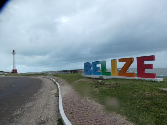 2019年10月22日(火)、午後の2時過ぎ。予定より1時間ほど遅れてベリーズシティ(Belize City)のフィリップ・S・W・ゴールドソン国際空港(Philip S. W. Goldson International Airport)に到着。小さな空港に大して大きくもない飛行機で着いたので、あっという間に入国完了。2時20分過ぎには早くもタクシーで移動開始。リンカーン(Lincoln)とは驚いた(下の写真)。ジャマイカもそうだけど、中南米の国ではアメ車は珍しいわ。<br /><br />向かうのはベリーズシティ。1972年までこの国の首都で、最大の人口(6万人強)を持つ。カリブ海に面し、ベリーズ川の河口の南約5㎞に位置する港湾都市。熱帯モンスーン気候で、年間を通して暖かく湿気が多い。雨季が長く、5月から1月まで続く。月間平均気温は、23度から28度。<br /><br />1638年にベリーズタウン(Belize Town)としてイギリスの木材収穫者によって設立された町。それ以前はホルズズ(Holzuz)と呼ばれるマヤ(Maya)の小さな村だった。以降、多くのアフリカ人奴隷が連れて来られ、木材の積出港として発展し、さらに金融と産業の中心地となり、首都となった。ちなみに1784年までは沖合の島、現在はリゾートホテルが中心で20人しか住んでいないセント・ジョージ島(St George&#39;s Caye)がこの国の首都だった。<br /><br />その後、1931年と61年のハリケーンで甚大なる被害を受け、首都は70㎞西南西の内陸部にあるベルモパン(Belmopan)に移転した。しかし、中央銀行がベリーズシティに所在するなど、一部の首都機能は保持している。2001年と2016年にもハリケーンの被害を受けている。<br /><br />ベリーズ唯一の都会で、町の規模は大きくないが、中米では珍しいイギリス統治時代の名残を残している。ホーラバー川(Haulover Creek)の河口にかかる橋で二つの地区が結ばれており、橋のたもとはカリブ海の島々への連絡船の発着場があり、街歩きの中心になる。<br /><br />20分余りで、その連絡船のひとつベリーズエクスプレス(Belize Express)の発着場に到着。ベリーズシティのタクシーは固定料金で、市内と空港間は事前に調べた通り片道50BZ$(25US$)だった。US$で支払い。普通にUS$の札は通用する。ちなみにこの国にはUberはないし、空港バスもないので、空港への足は自家用車、レンタカー以外はタクシーしかない。<br /><br />発着場では、まずは奥(海側)にある窓口でチケットを購入。この連絡船のチケットの購入にはティップスがあるのだが、その話は実際の移動の話にまとめて書くことにする。で、チケットを購入するとキャリーバックを預けられるので、1時間ちょっと先の4時の便に乗ると云うことで預ける。3時の便にも乗れると云われるが、町を一回りするのでと云ってお断りする。で、身軽になったので散策に出掛ける。<br /><br />まあ散策と云ってもさほど見るところはない町のではあるが、まずは、ベリーズエクスプレスターミナルからさらに半島の先に進む。5分余りで先端部分まで着くのだが、そこにあるのがブリス男爵灯台(Baron Bliss Lighthouse)とベリーズウェルカムサイン(Belize Welcome Sign)。高さ15mある灯台は、1926年にこの町の沖合に停泊していたヨットで亡くなったイギリス人、ブリス男爵(Baron Bliss)が、「ベリーズの漁師の人たちが、迷わずこの場所へ帰ってこられるように」という願いを込めて建設を指示したもの。彼は一度もベリーズに上陸したことはなかったが、ベリーズに残した信託基金で建てられた。ウェルカムサインは2014年に地元の弁護士のエステバン・ぺレーラ(Estevan Perera)氏がビーチフロントの活性化のために建てたもので、カラフルで可愛らしい、新しい記念撮影スポットとなっている。<br /><br />雨が降り出す中、来た道を戻り、ターミナルを通り過ぎて、さらに少し進むと左手にスイング橋(The Swing Bridge)。ベリーズシティ市内の真ん中を流れるホーラバー川の河口に架かる橋で、中米最古の旋回橋。手動で橋を回し、船を通す仕組みになっており、以前は朝6時と夕方6時に開いていたそうだが、今は旋回してない。回ってないと単なる古い橋だね。<br /><br />次は、スイング橋からこの町のメインストリートであるクイーン通り(Queen St.)を北東に10分足らず進むとベリーズ博物館(Museum of Belize)。19世紀中頃に建てられ、1993年まで刑務所として使われていた建物を改装し、2002年に公開された歴史自然博物館。1階はベリーズシティの歴史を、度重なるハリケーンや火災の被害を中心に紹介。2階にはベリーズのマヤ遺跡のコーナーがあり、翡翠の像や仮面にペンダント、陶器、そして人骨などの出土品を展示。さらに奥にはベリーズの自然や植物、昆虫についての展示。きれいな蝶の標本もあった。入館料は10BZ$(5US$)。<br /><br />15分ほどで博物館の見学を終え、ベリーズシティ観光は早々と終了。ベリーズエクスプレスターミナルに戻るが、ターミナルの向かいにある聖メアリー教会(St Mary&#39;s Church)は1883年創立と書いてある。ただし、現在建っている建物がその当時のものかどうかは不明。<br />https://www.facebook.com/chifuyu.kuribayashi/media_set?set=a.3502577326478933&amp;type=1&amp;l=223fe1adec<br /><br />3時45分頃、ターミナルに戻って来て、まだ少し時間があるので、パナマシティの空港のセキュリティに取り上げられたライターの代わりを探す。適当にターミナルの土産物屋を覗いて、土産用のベリーズライターがないか探してたら、カウンターの奥から「あるよ」って感じで出してくれた(HEROかい!)。3US$だったので、ジャマイカライターより少し安い。まあ、自分への土産にもなるからいいかな。<br /><br /><br />キーカーカーへ続く。