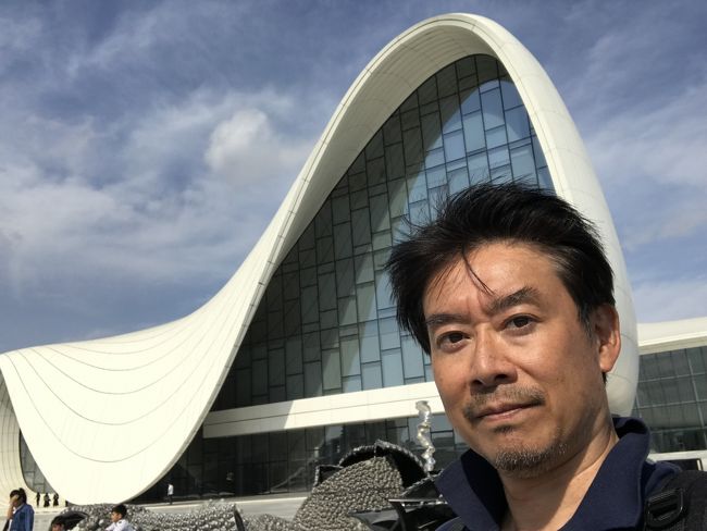 中央アジアの旅、最後の国はアゼルバイジャンです。ほぼ何の予備知識もなしに行ったのですが、街はイタリア風、女性たちは美人でスタイル抜群と、こんなにいい国を知らずにいたなんてもったいない話でした。「風の街バクー」と言われるように時々強風も吹きますが、そんなもの、人の親切さが補って余りありです。ノーマークだった方には、ぜひ旅の行き先としてご検討をお薦めします。<br />写真はかの有名なザハ・ハディッド氏設計の、「ヘイダル・アリエフ・センター」です。<br />ビザは到着時に無料でもらえます。左手にマシンと優しそうな説明おじさん、右手に両替所と並んで免許センターのような窓口。僕は右を選んでしまいました(なんだか残念)。確か名前とかメールアドレスを記入して渡すと、係員がノートパソコンで処理。「スマホを、カメラアプリが起動した状態で渡して」と言われて渡すと、パソコン画面を撮影して返してくれました。そこにビザの番号が示されていて、その後「ビザの画面はこちら」というリンクを教えるメールが届きました。無料です。きらびやかなシールが貼られたりすることを期待したけど、今はデジタルの世の中ですね。