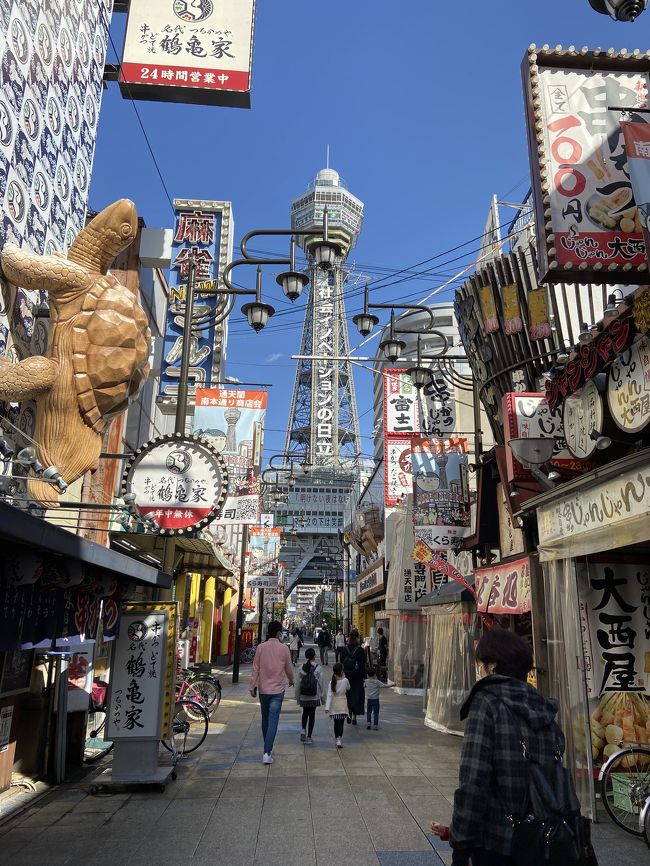 大阪の象徴とも言える通天閣に初めて登ってみました。<br />大阪メトロの御堂筋線で動物園前駅より徒歩5.6分ほどのところにありました。<br />駅を降りると大阪の下町というような独特な世界観。<br />通天閣に続くメイン通りはたくさんの串カツ屋さんが並んでいて、残念ながら閉店してしまったフグ料理で有名な<br />づぼらやさんもありました。<br />ちょうどづぼらやさんの前あたりが、賑やかな街並みと通天閣を見渡せる1番いい写真スポットでした。<br />通天閣へ登るには一度地下の券売所まで行きチケットを買います。<br />3歳までは無料、5歳以上は400円、大人は800円です。<br />チケットを買ってすぐにエレベーターで上の階にあがって行き、5階の黄金の展望台に到着です。<br />この日はとても晴れていて大阪の街並みが一望出来ました。<br />通天閣といえば足を撫でるとご利益があると言われているビリケンさんがいますが、コロナ渦の為エアータッチでお願いしますと張り紙がありました。<br />ちなみにもう一つ上の階にある特別展望台はまた別料金で500円かかります。5歳以下の子供は登れません。<br />展望台以外にも展示物がたくさんあり、お土産屋さんもあり楽しかったので大阪に遊びに行ったらまた行きたいなと思います。